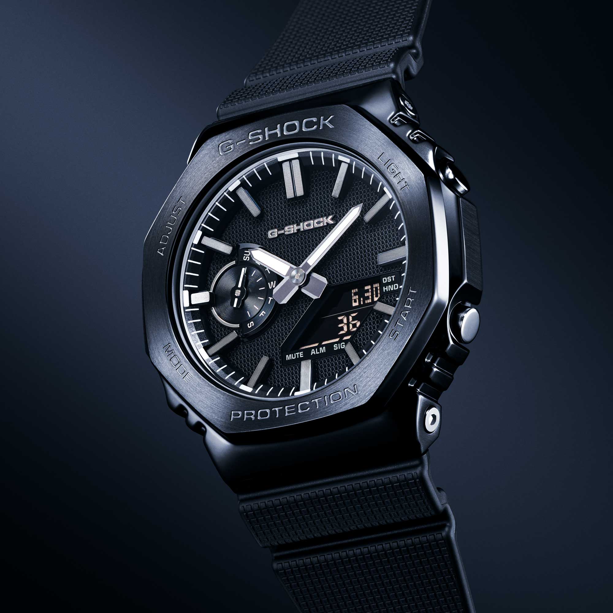 Schwarze G-Shock GM-2100LXB-1A Analog-Digital-Uhr mit achteckigem Gehäuse, schwarzem Zifferblatt und robustem Resin-Armband vor dunklem Hintergrund.