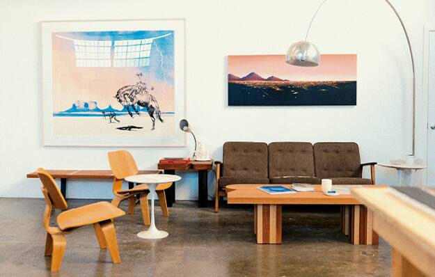 Der Empfangsbereich im Atelier des Künstlers McCormick mit Sofa, Stühlen und Tisch. An der Wand zwei seiner Gemälde. Das Bild verlinkt zum Creator Interview mit Matt McCormic.