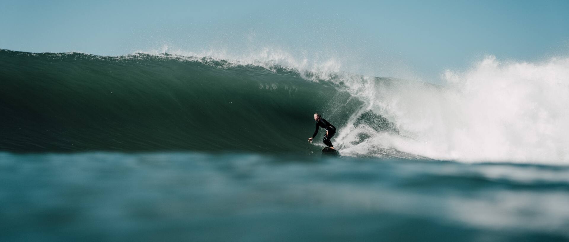 Christina Gindl surft in der Barrel einer großen Welle