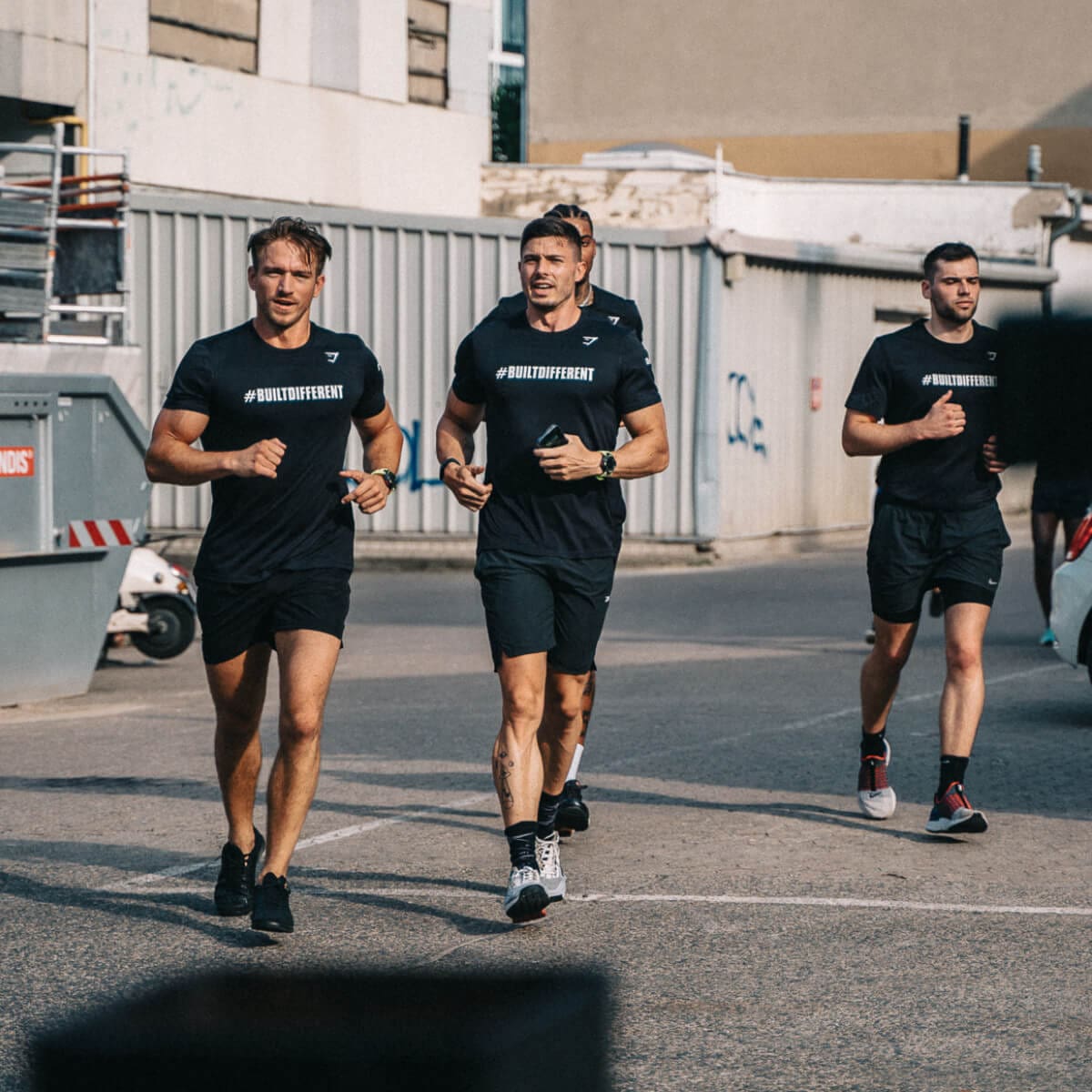 Eine Gruppe von Personen joggt bei Sonnenschein auf einer asphaltierten Straße. Zum Tracken des Trainings wird die G-SHOCK GBD-H2000 genutzt.