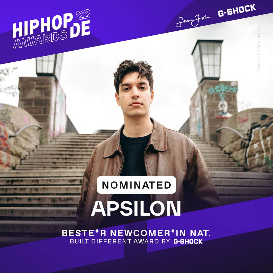 Rapper Apsilon steht in schwarzem Shirt und Lederjacke vor einer Treppe und war als bester Newcomer national nominiert