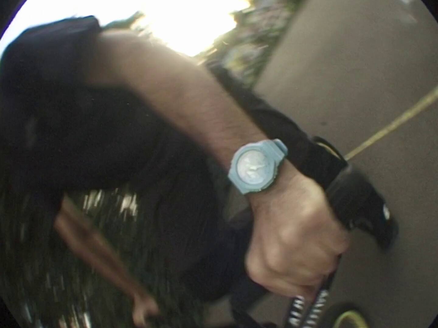 Eine Person trägt die hellblaue GA-2100 Armbanduhr von G-SHOCK während er auf seinem BMX fährt