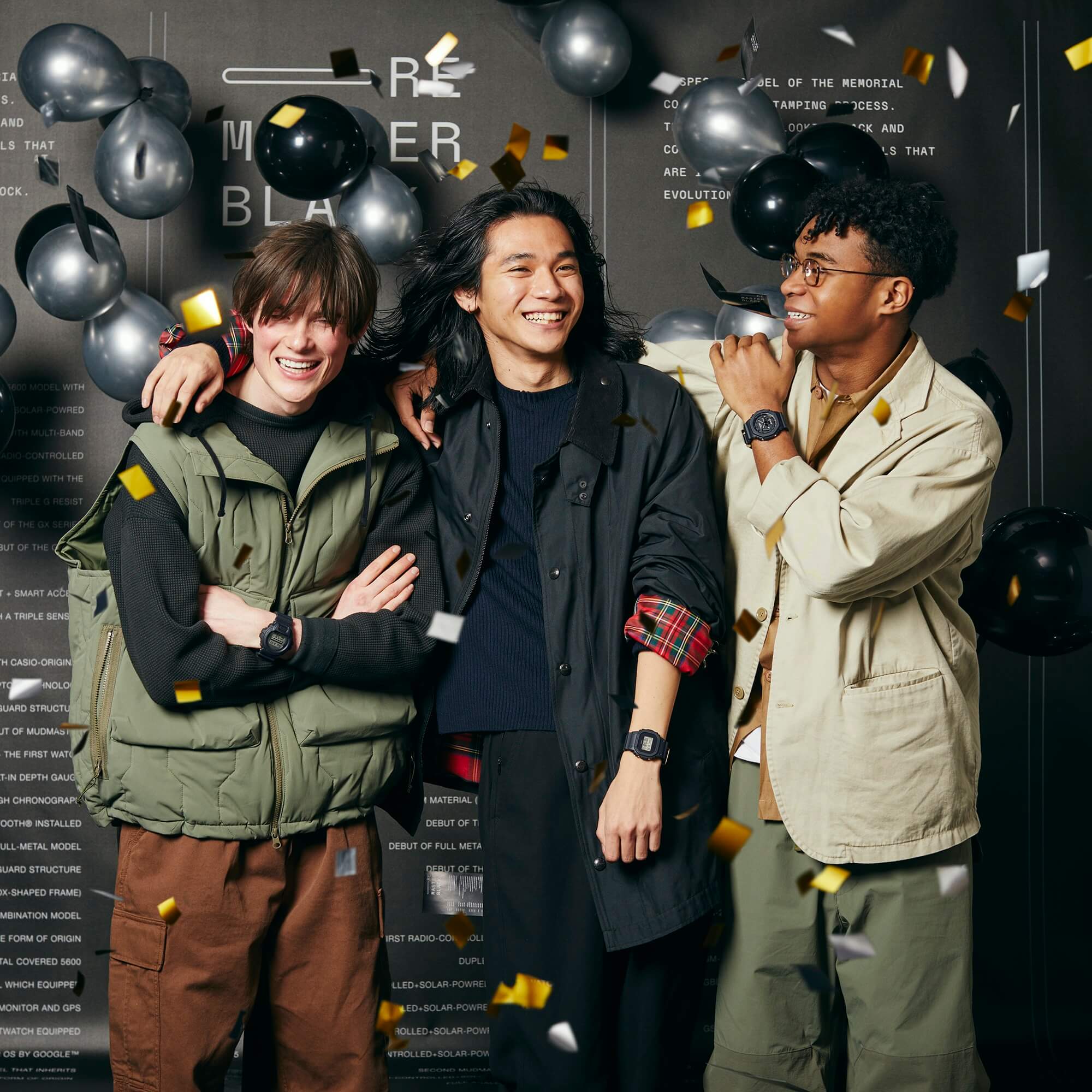 Drei Personen stehen vor einer schwarzen Wand mit Luftballons und goldenem Konfetti, feiern das 40-jährige Jubiläum von G-SHOCK und tragen Uhrenmodelle der Remaster-Serie an ihren Handgelenken.