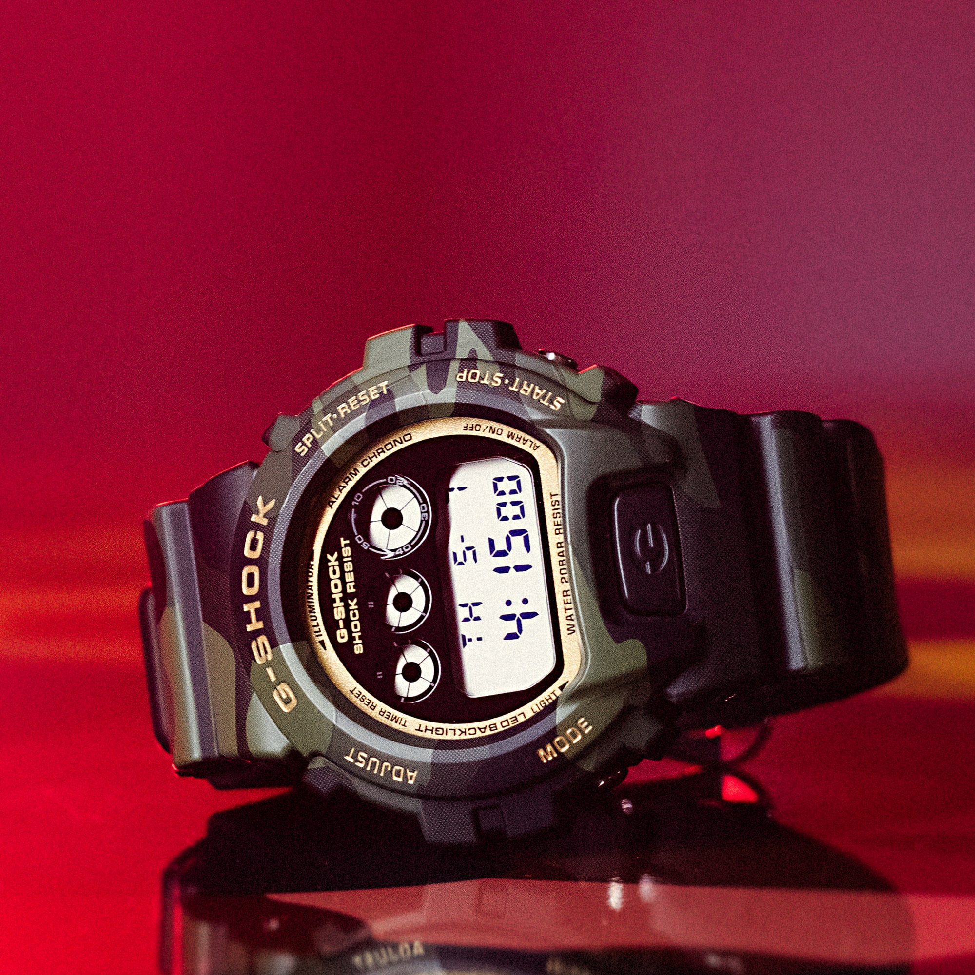 Die DW-6900 Armanduhr aus der Camouflage-Serie mit digitaler Anzeige und goldfarbenen Details.