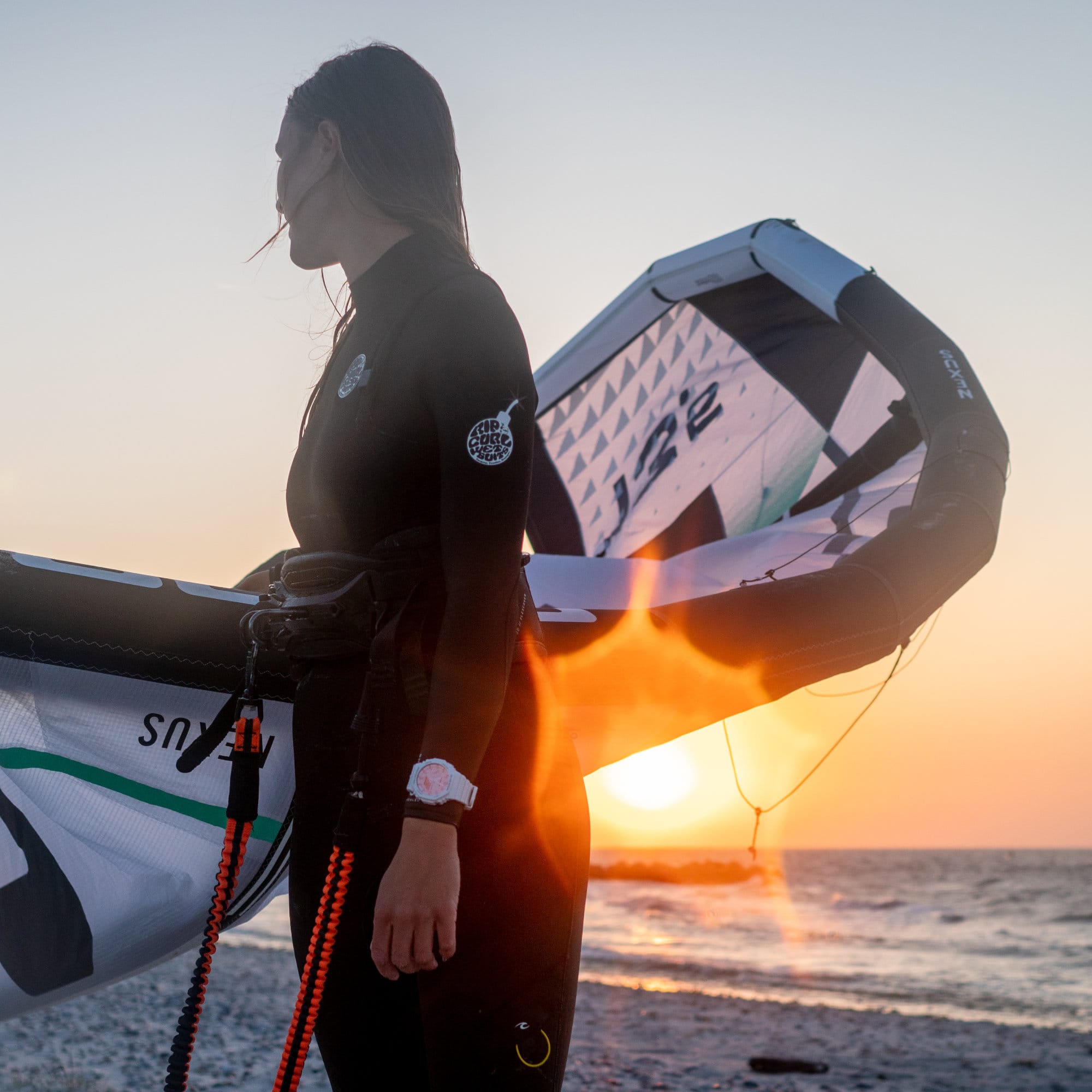 Eine Kitesurferin am Strand mit der GA-2100TL-7A von G-SHOCK ums Handgelenk