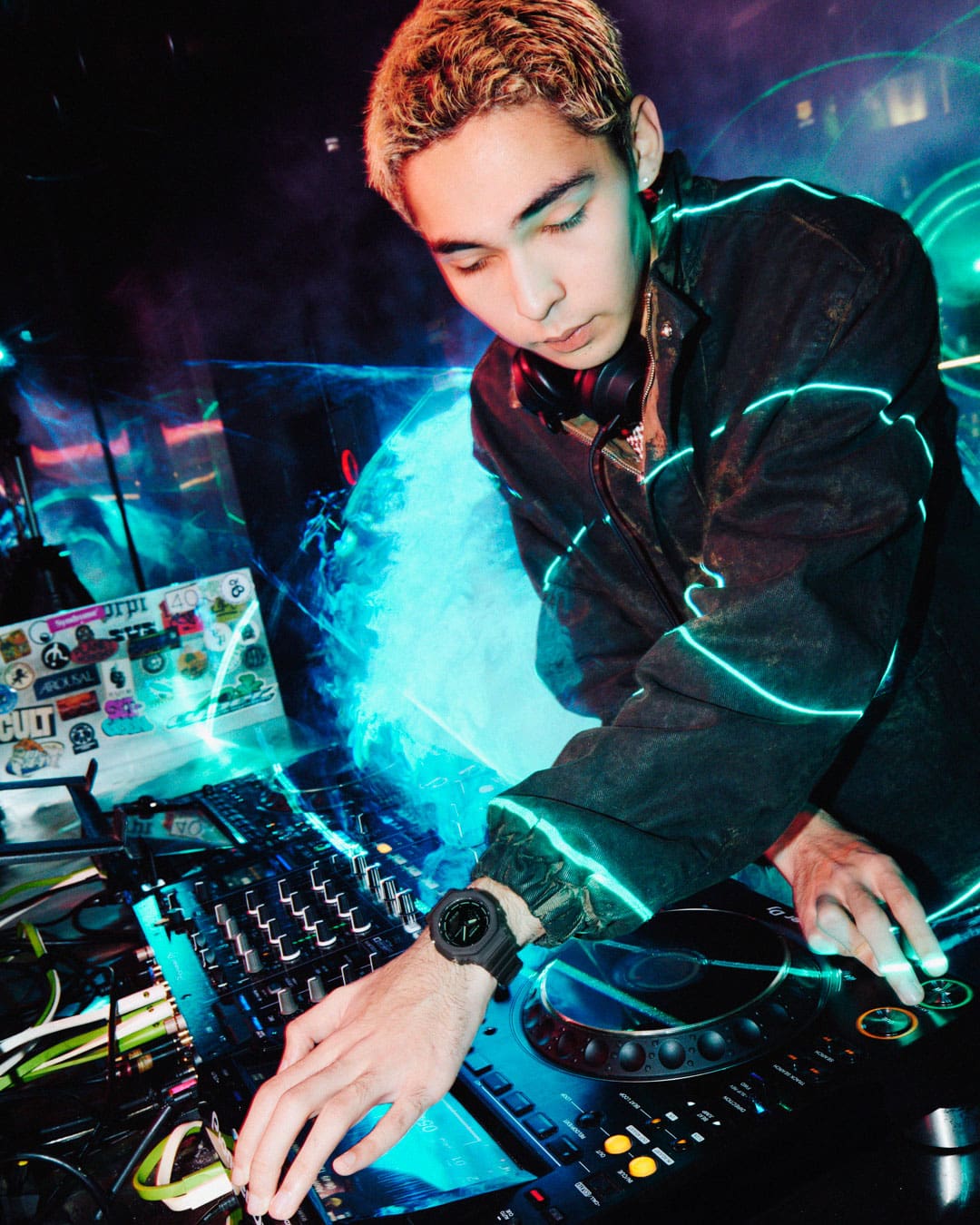 Ein DJ, der die G-Shock GA-2100K-1A trägt, während er in einem Club Musik auflegt.