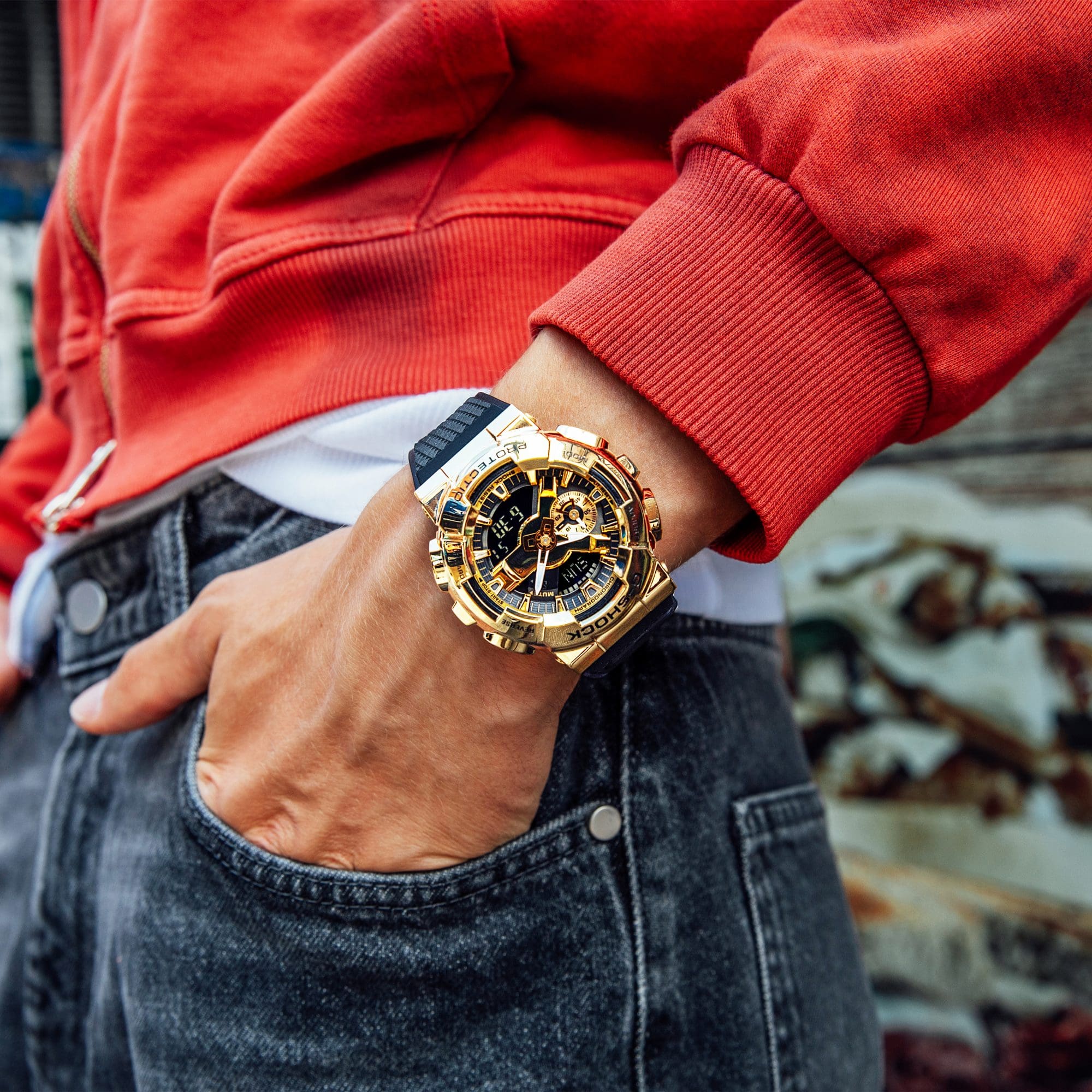 Die Casio G-Shock GM-110 Hybriduhr mit goldenem Gehäuse und schwarzem Armband an einem Handgelenk getragen