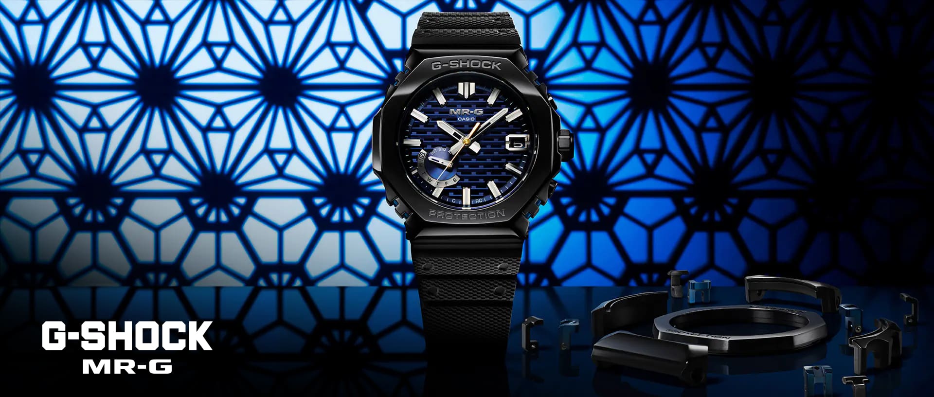 Die schwarze MRG-B2100R Armbanduhr von G-SHOCK mit dunkelblaugemusterter Lünette vor einem blaugemustertem Hintergrund.