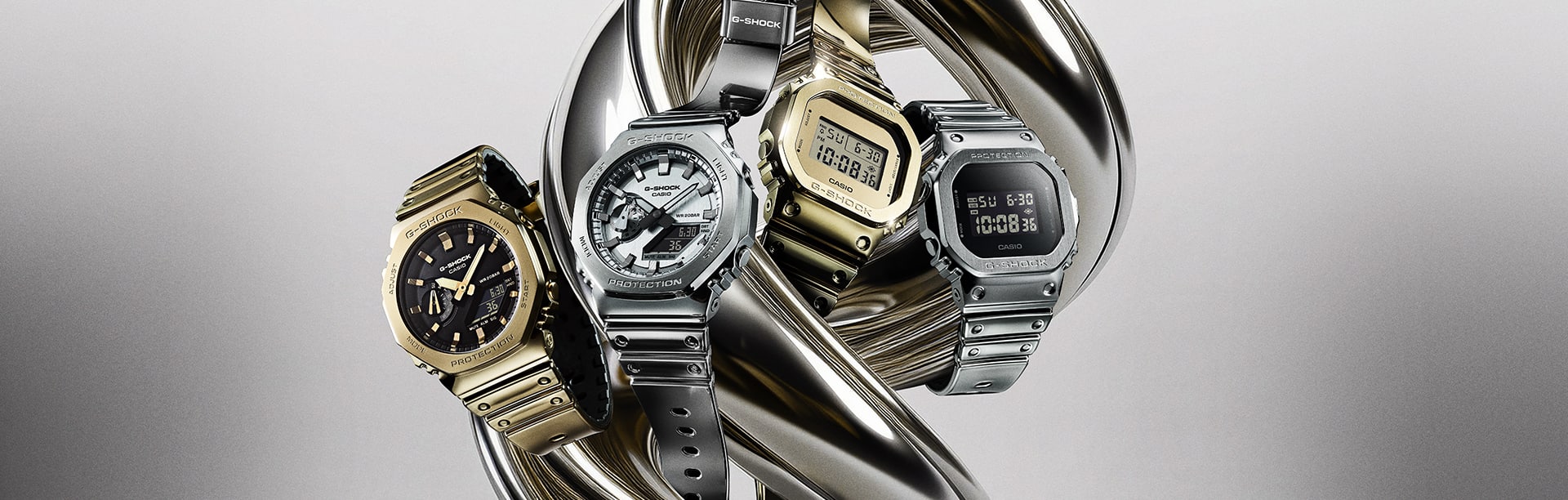 Metal watches with silicone watch bands denoting the style of a G-SHOCK gold & silver watch collection: Fine Metallic Series