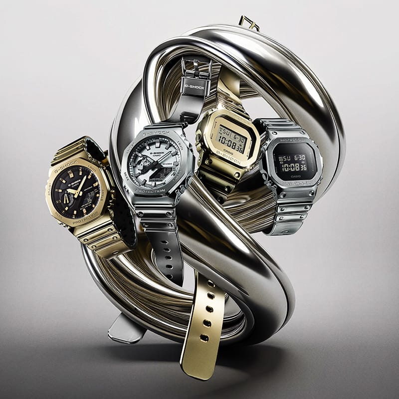 Metal watches with silicone watch bands denoting the style of a G-SHOCK gold & silver watch collection: Fine Metallic Series