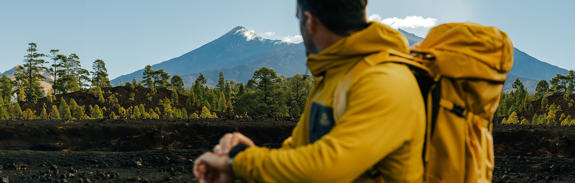 Hiker glancing over shoulder at mountain