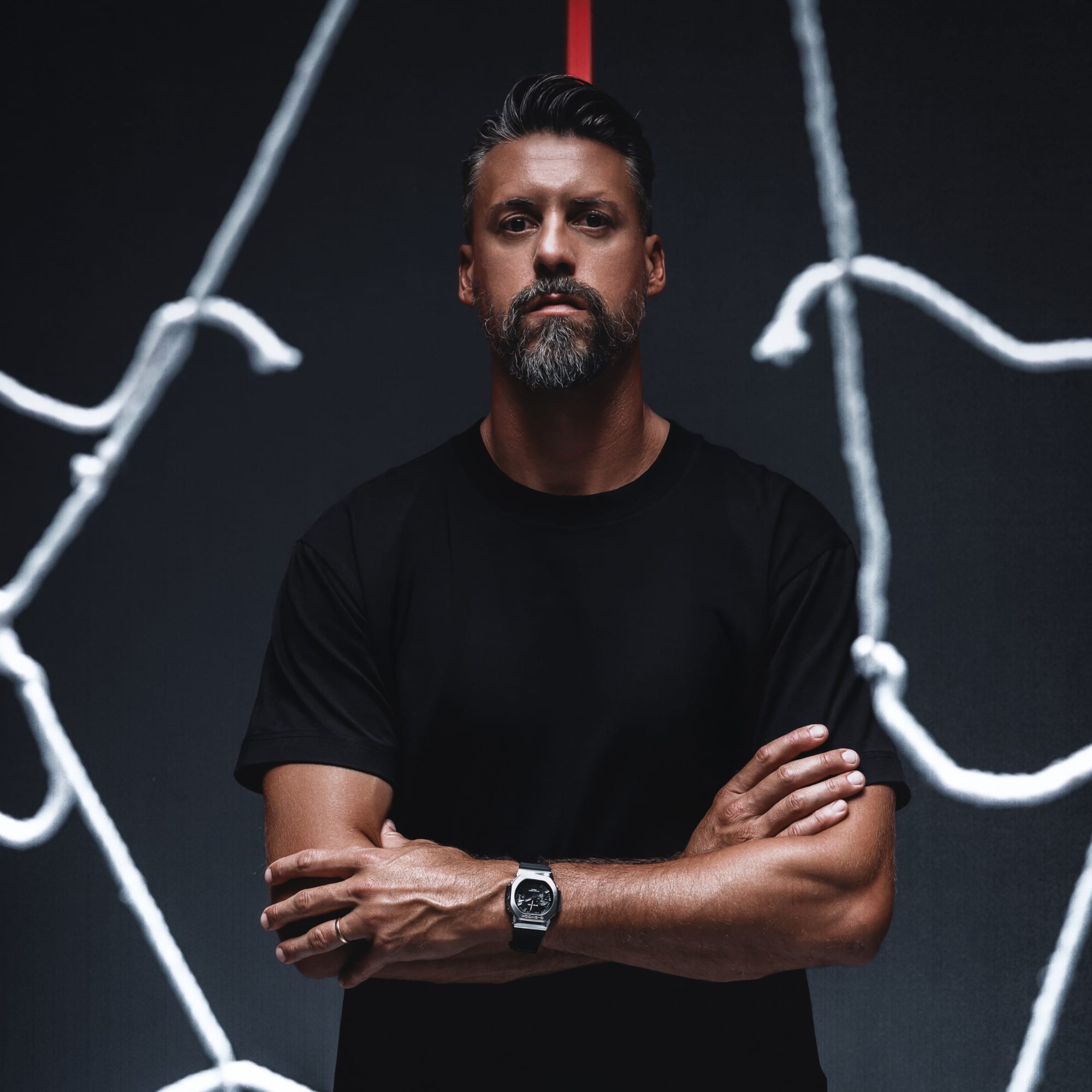 Sandro Wagner steht mit verschränkten Armen in einem Fußballtor. Am Handgelenk trägt er die GMC-2500 G-SHOCK Uhr. Externer Link zur Kooperations-Landingpage.