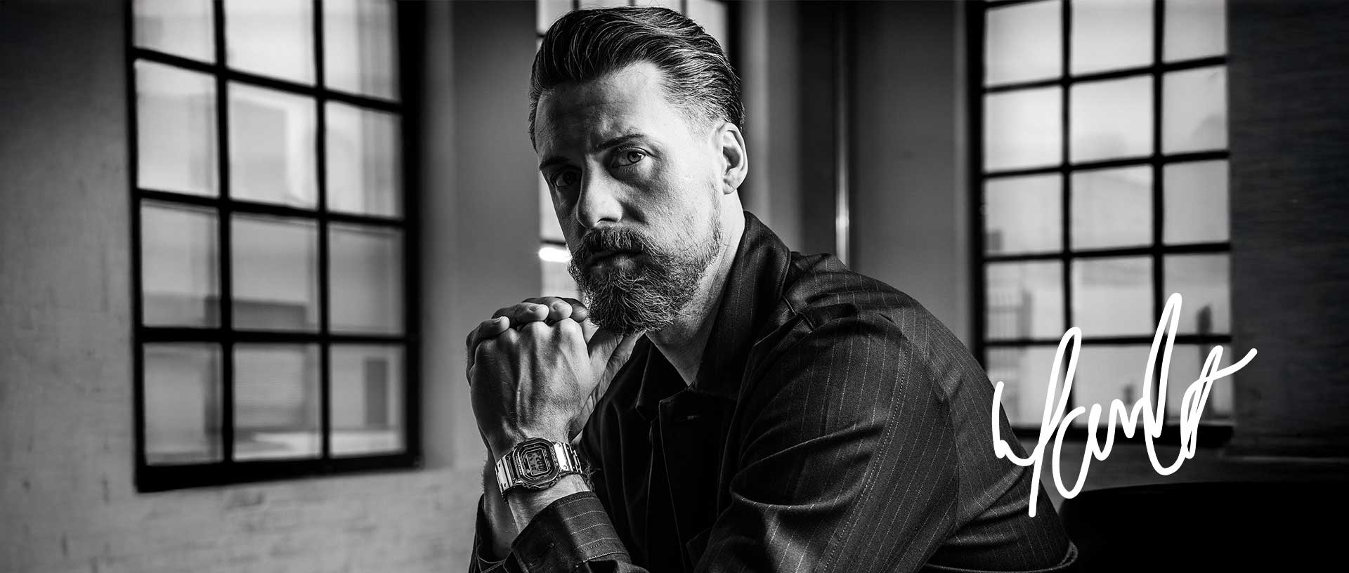 Schwarz-weiß Portrait von Sandro Wagner, der sein Kinn auf den Händen abstützt, am Handgelenk trägt er eine Metall-Uhr von G-SHOCK