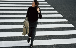 Eine Person in einem modischen Outfit überquert einen Zebrastreifen. Am Handgelenk trägt sie eine silberne G-Shock Armbanduhr. Das Bild verliinkt zur Seite: G-Shock Marais Paris Store