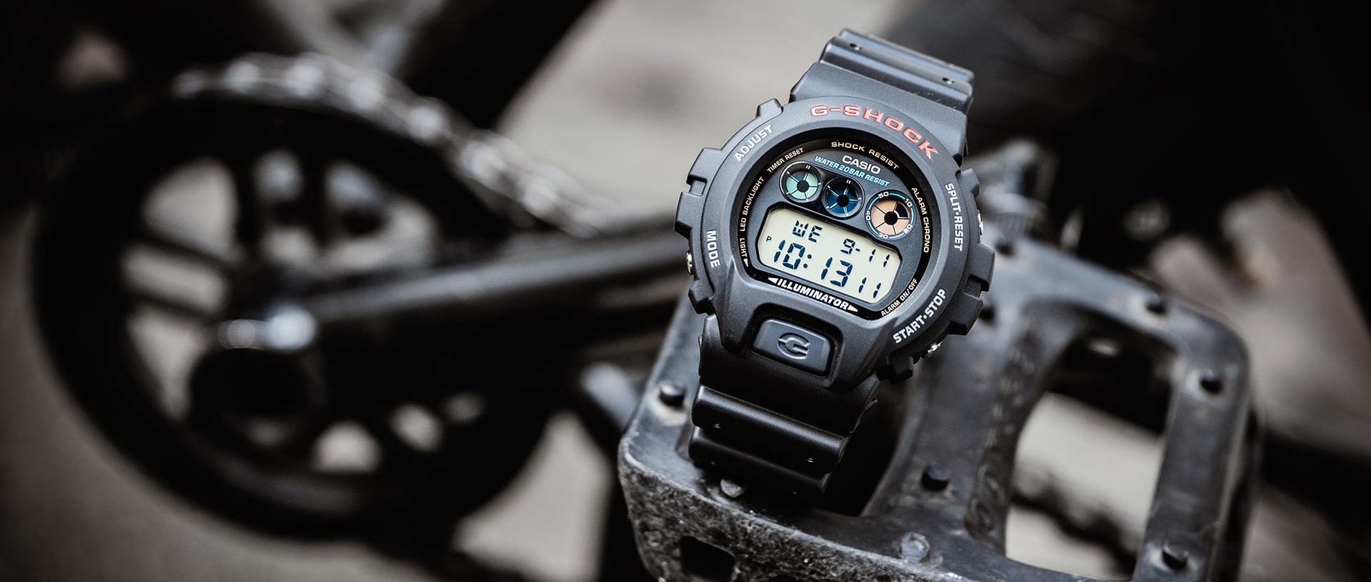 Die G-SHOCK DW-6900 Armbanduhr in schwarz mit großem, rundem Gehäuse und kleiner digitaler Anzeige, unter der Anzeige ist ein großer Knopf mit einem "G". Das Armband ist schwarz und aus Resin.