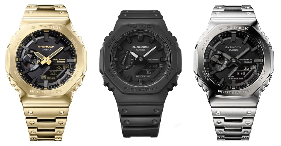 Drei G-Shock 2100 Hybriduhren mit schwarzem Zifferblatt und unterschiedlichen Armbandvarianten: links mit goldfarbenem Metallarmband, in der Mitte mit schwarzem Resinarmband, rechts mit silbernem Edelstahlarmband