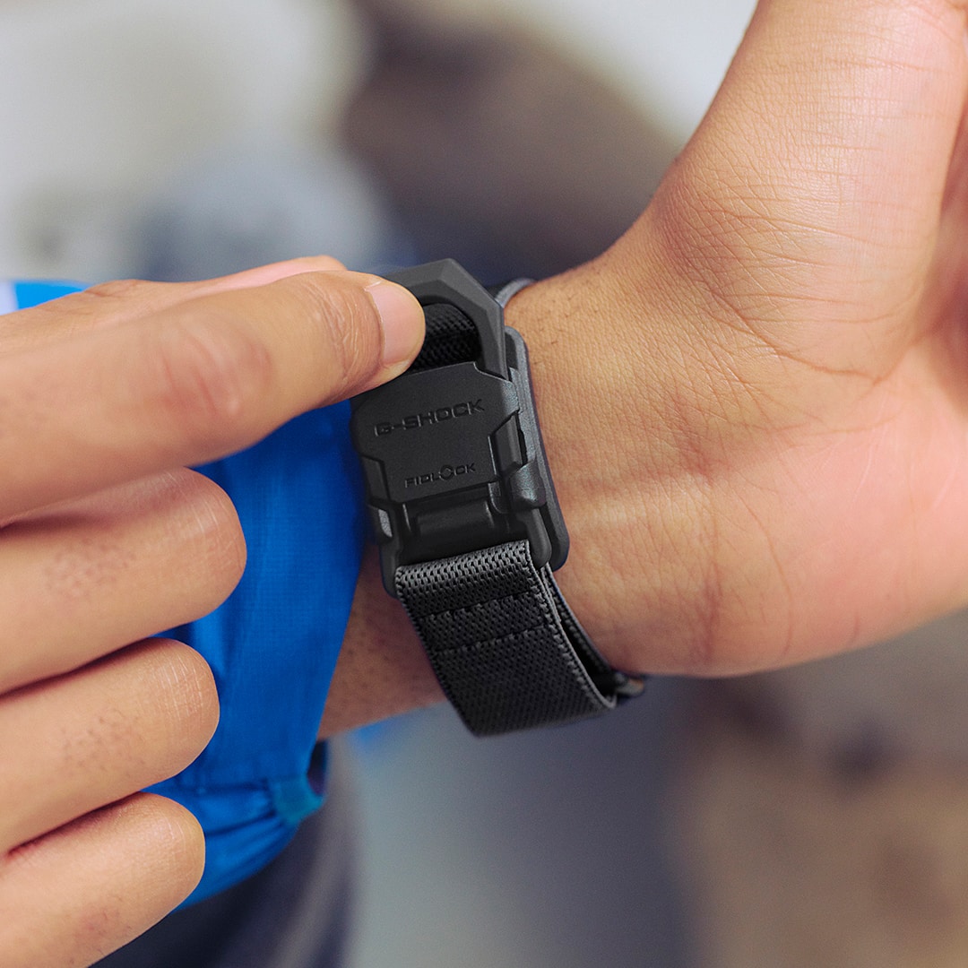 G-SHOCK DW-5600MNC am Handgelenk, während der magnetische Fidlock-Verschluss durch Druck geschlossen wird.