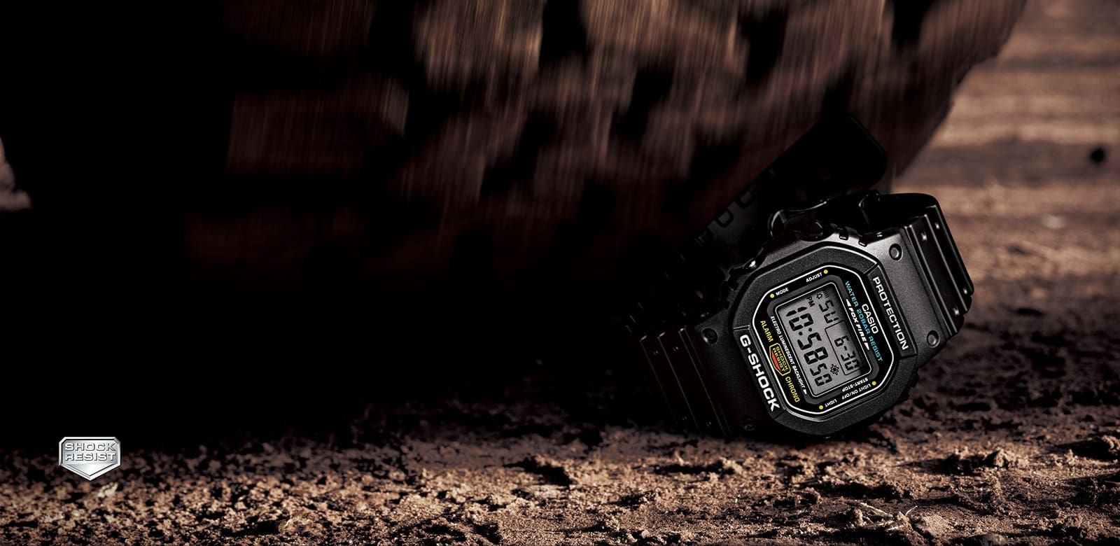 Shock Resistance G-SHOCK liegend im Sand mit dem Test der Stoßfestigkeit