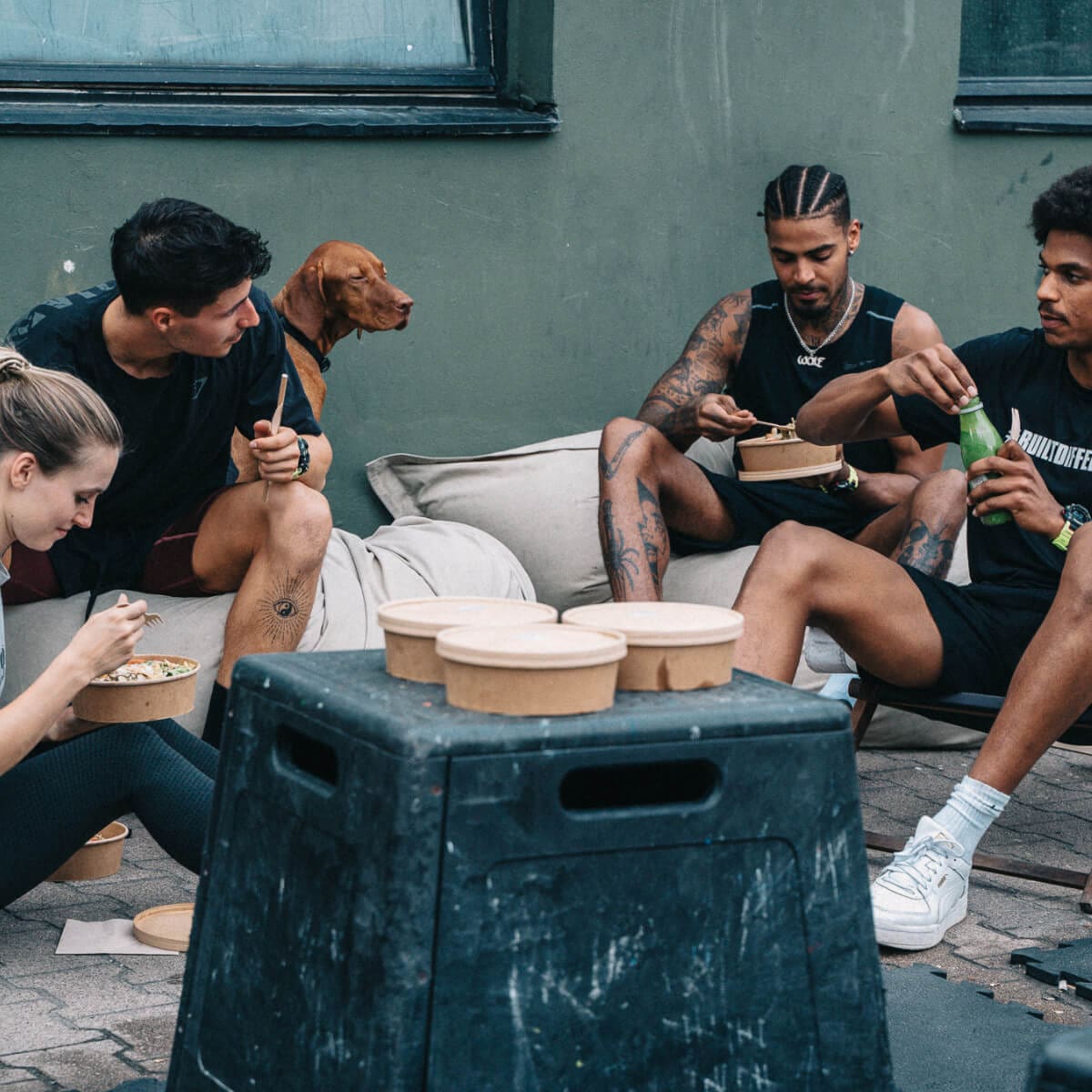 Un grupo de atletas comiendo cuencos después de entrenar.