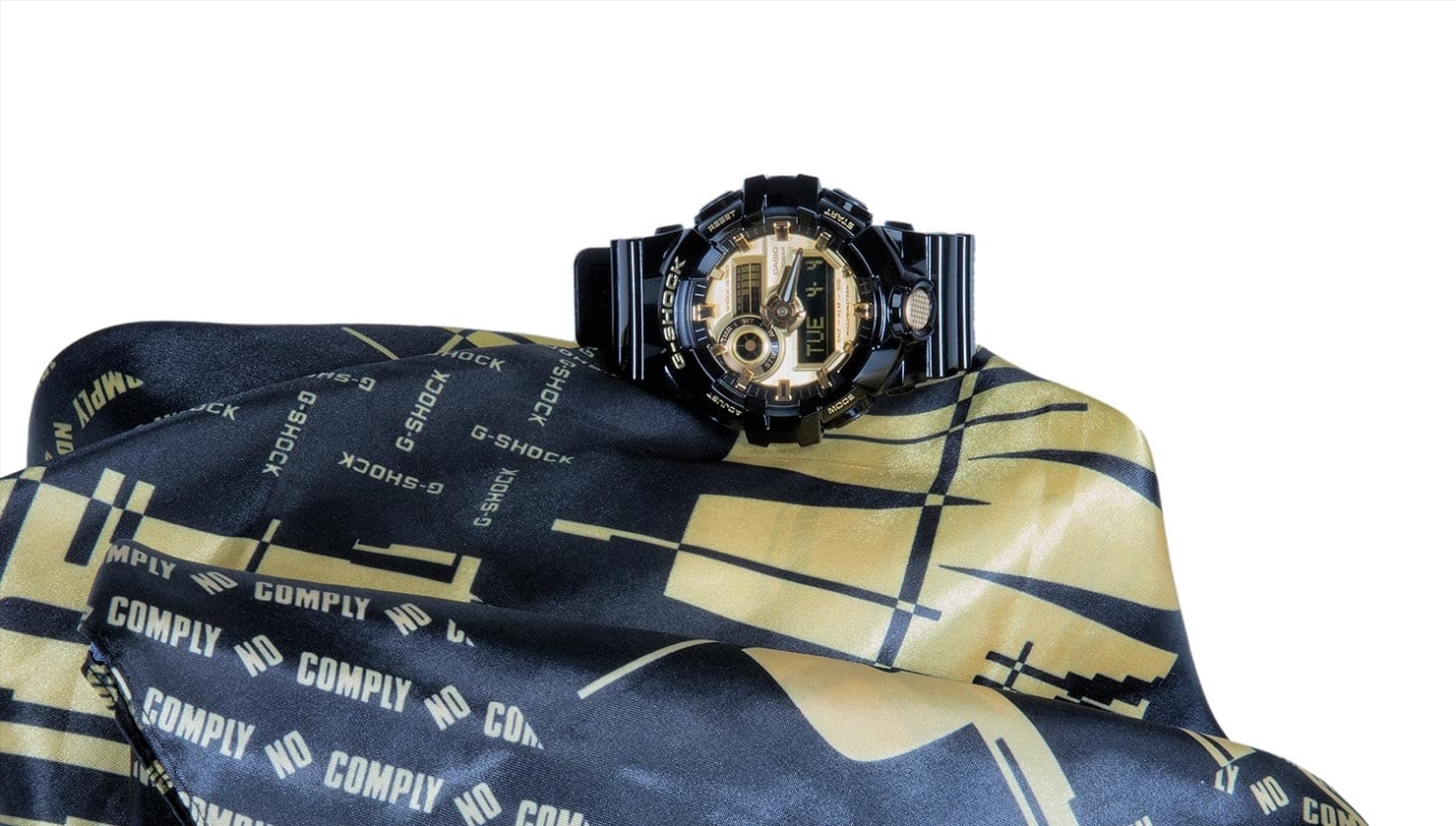 El reloj de colaboración en tela negra y dorada con la marca No Comply