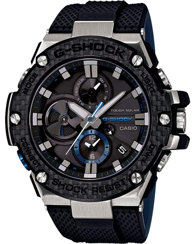 El reloj de pulsera «GST-B100» de G-SHOCK con correa de resina negra, cierre plateado en la caja y robusta caja redonda de color negro-gris, así como pantalla analógica y detalles azules.