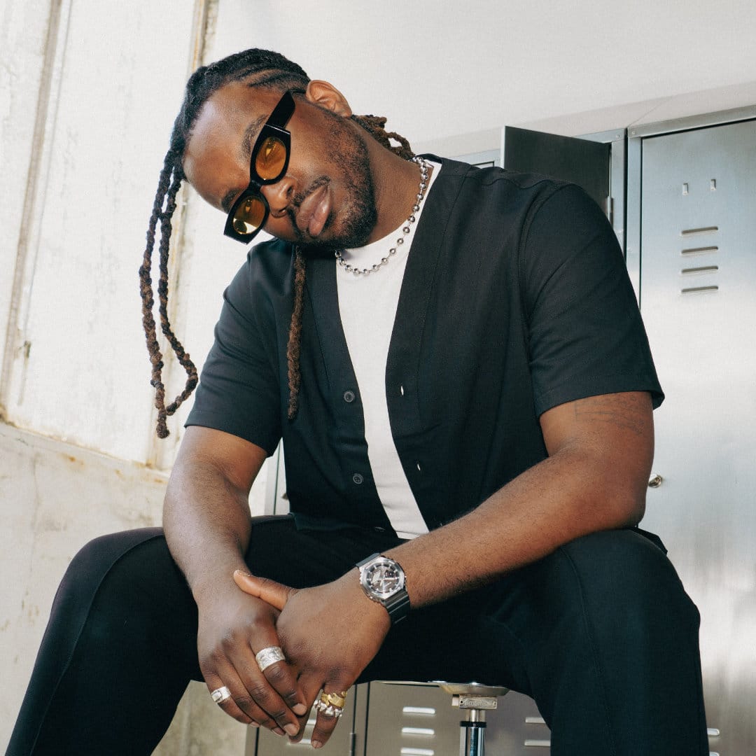 Un modelo masculino con ropa negra lleva el GBM-2100 con pulsera negra y bisel metálico