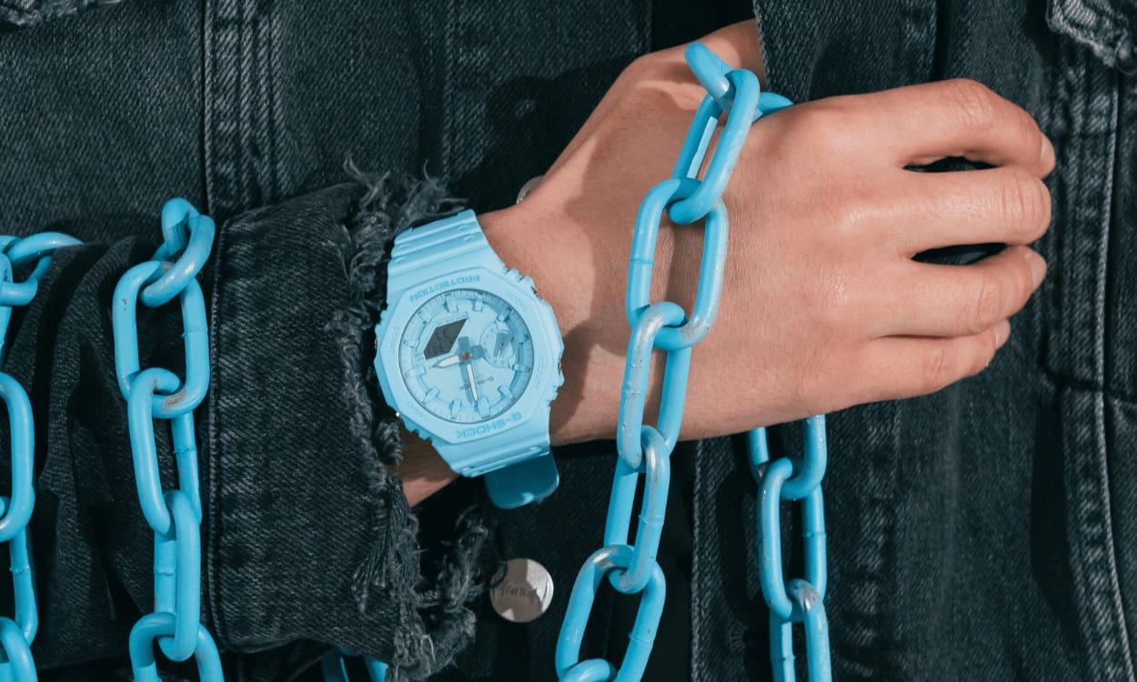 Un hombre lleva un reloj pulsera azul G-SHOCK "GA-2100"
