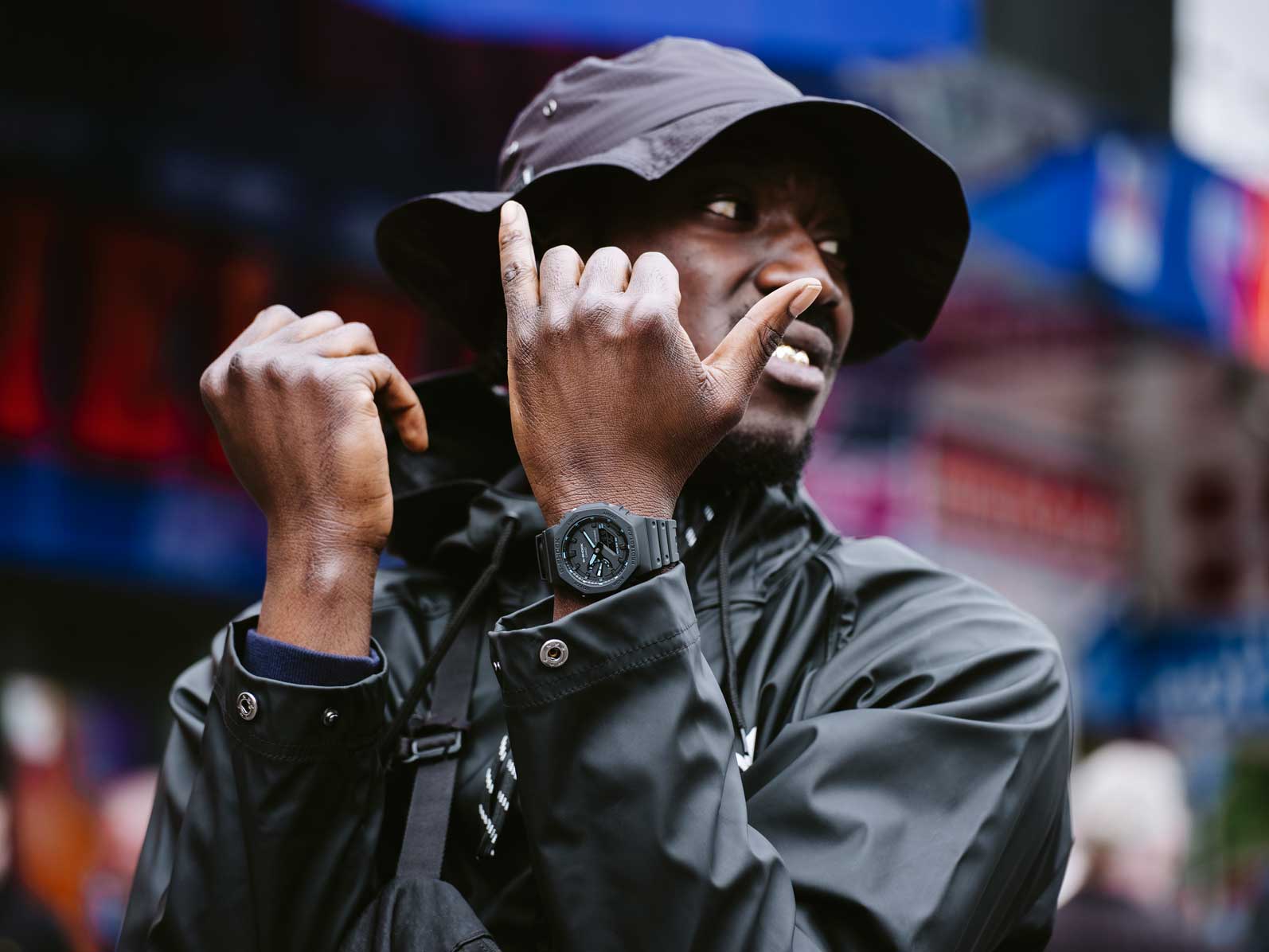 Rapper "Kwam.E" auf der Straße mit schwarzer Jacke, schwarzem Buckethat und schwarzer G-SHOCK Uhr