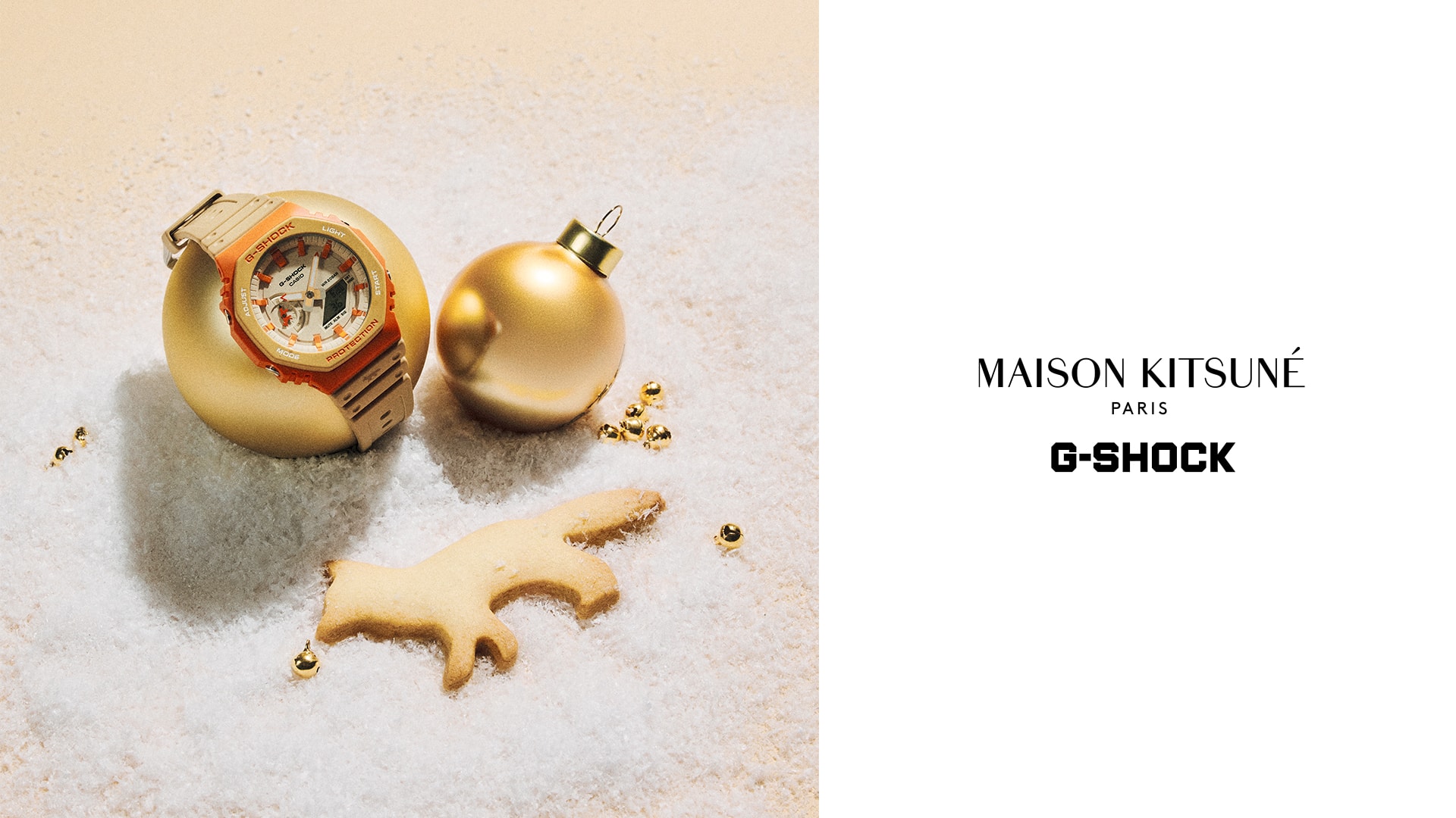 The G-SHOCK GA-2100MK-5A collaboration watch with Maison Kitsune in beige and orange bent over a golden christmas bauble