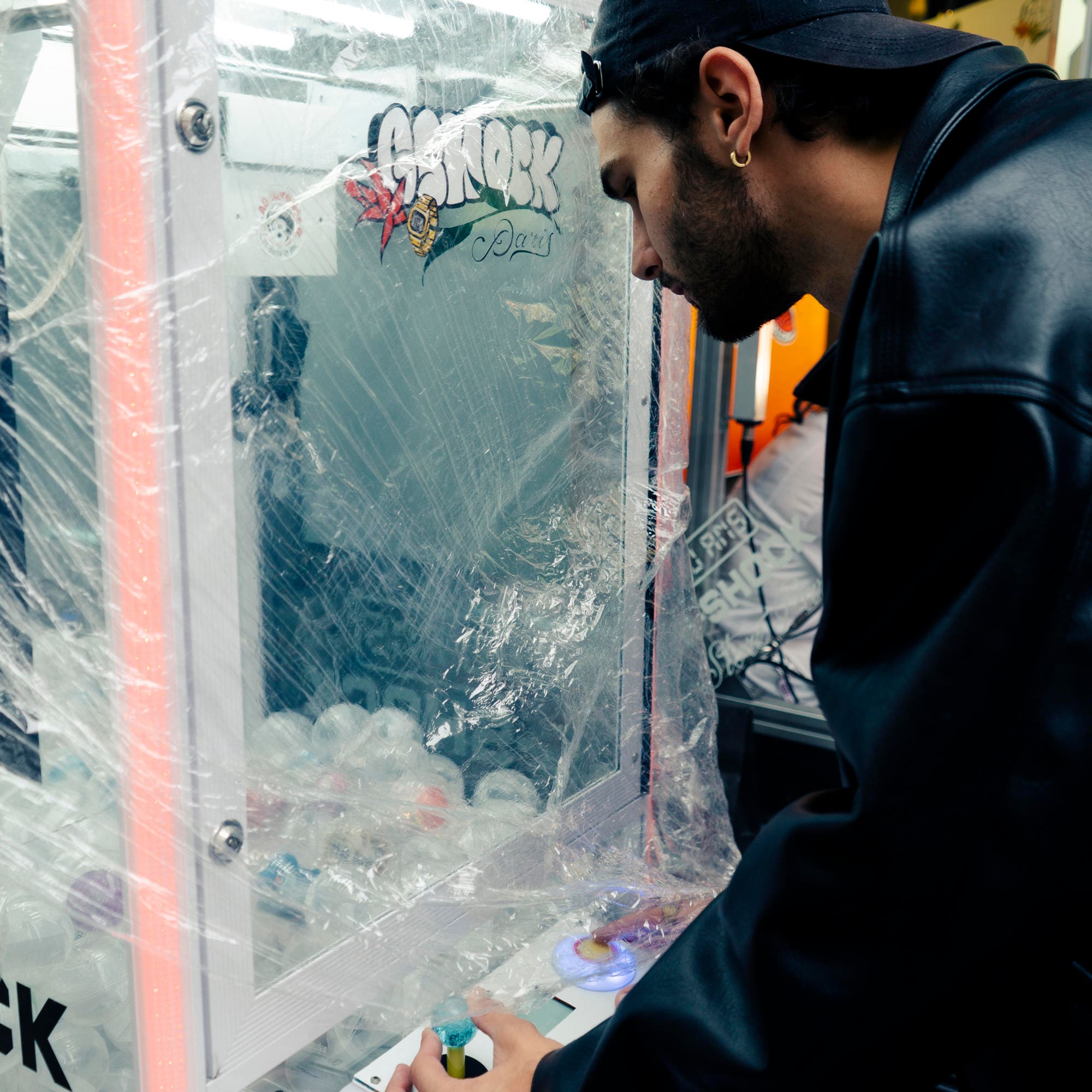 Un homme se tient devant une machine à sous dans le G-SHOCK Store de Paris