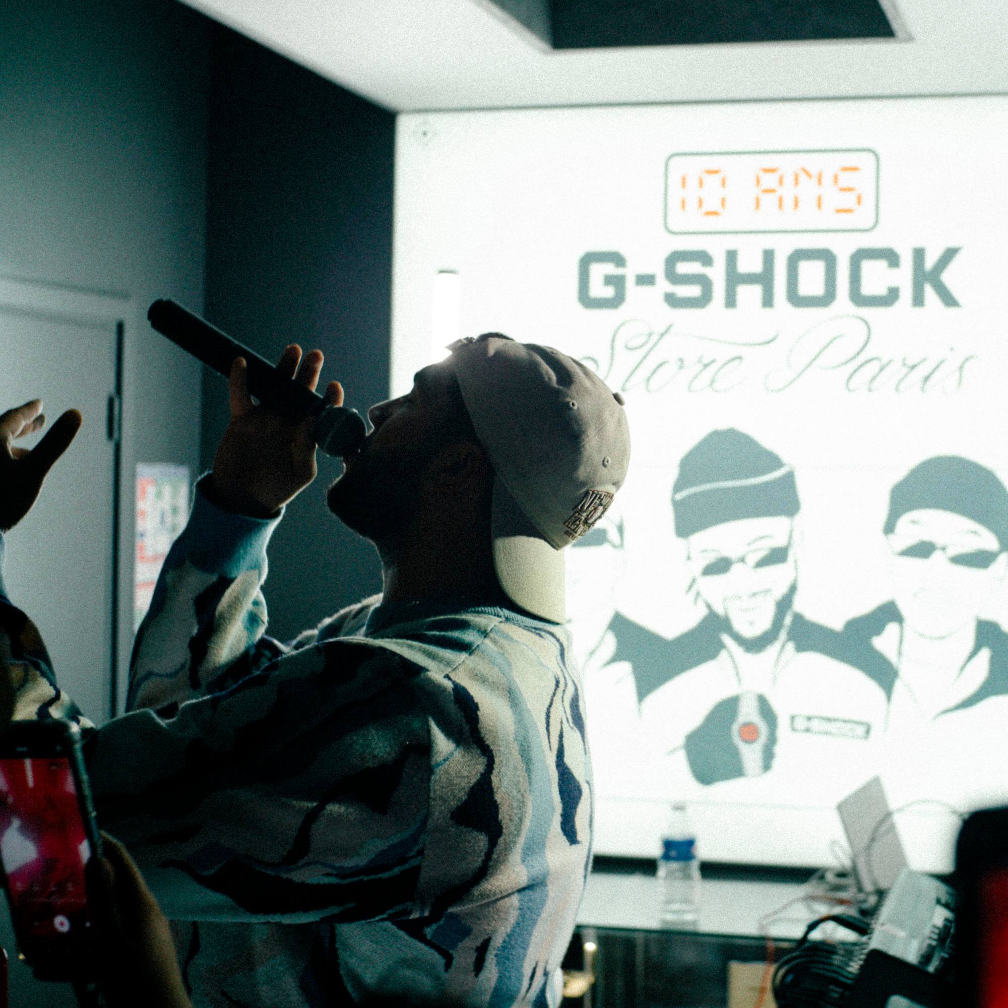 Un rappeur se tient devant une projection G-SHOCK des années 40, un micro à la main.