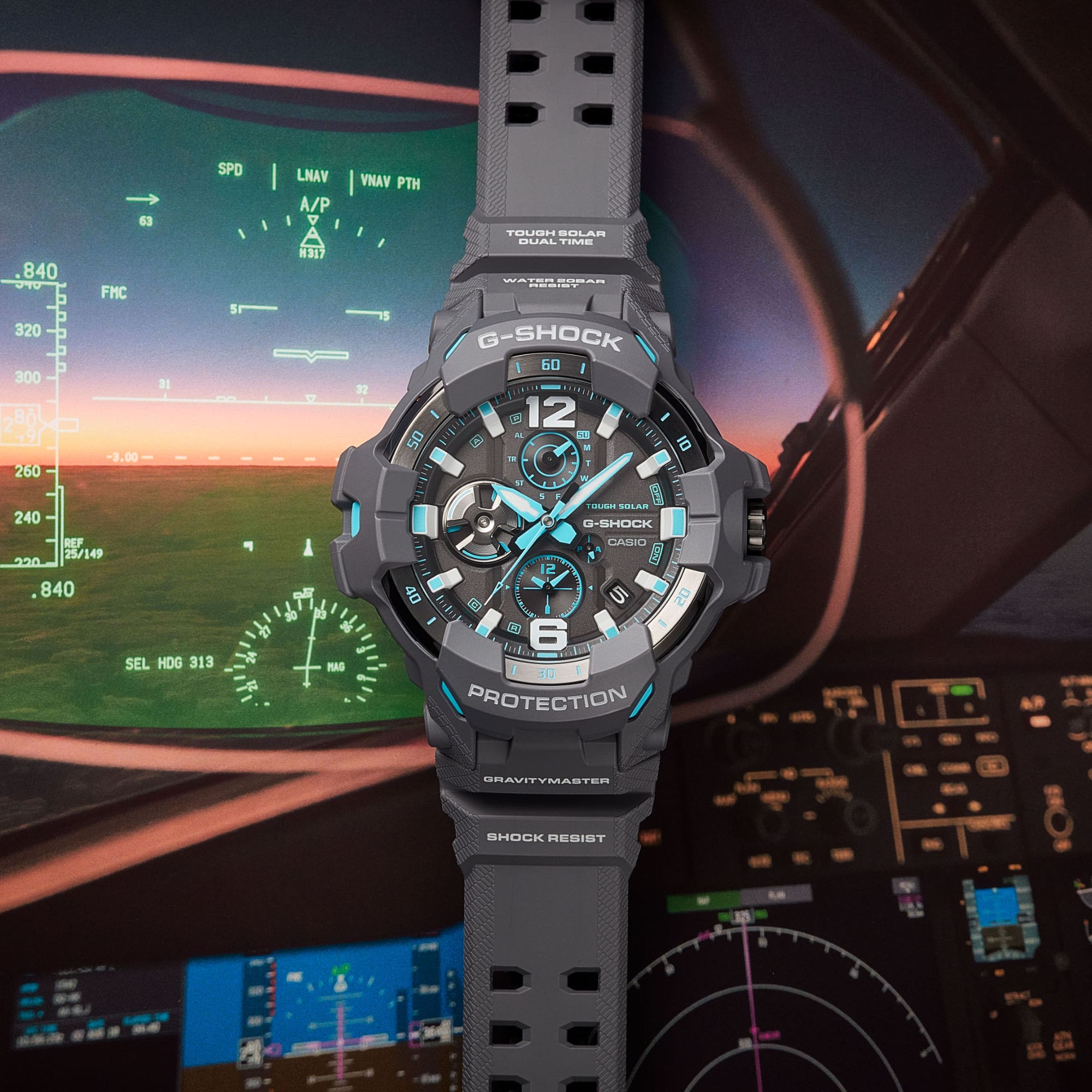 La montre GR-B300-8A2 de G-SHOCK avec cadran analogique devant un cockpit illustré
