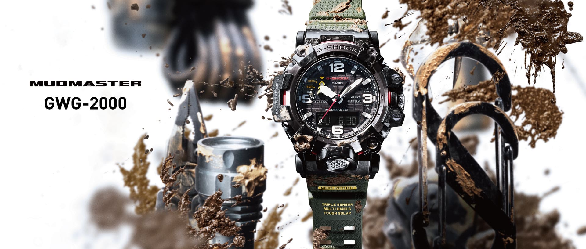 Le modèle de montre « GWG-2000 » avec affichage analogique, grand boîtier rond et bracelet en tissu de couleur olive à côté d'outils de forage et de boue.