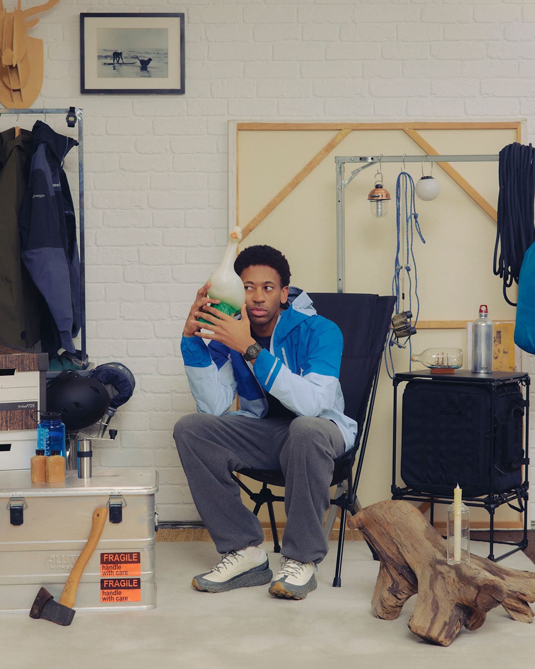 Un homme est assis dans un intérieur. Il porte une tenue de plein air et la G-SHOCK DW-5600MNC au poignet.