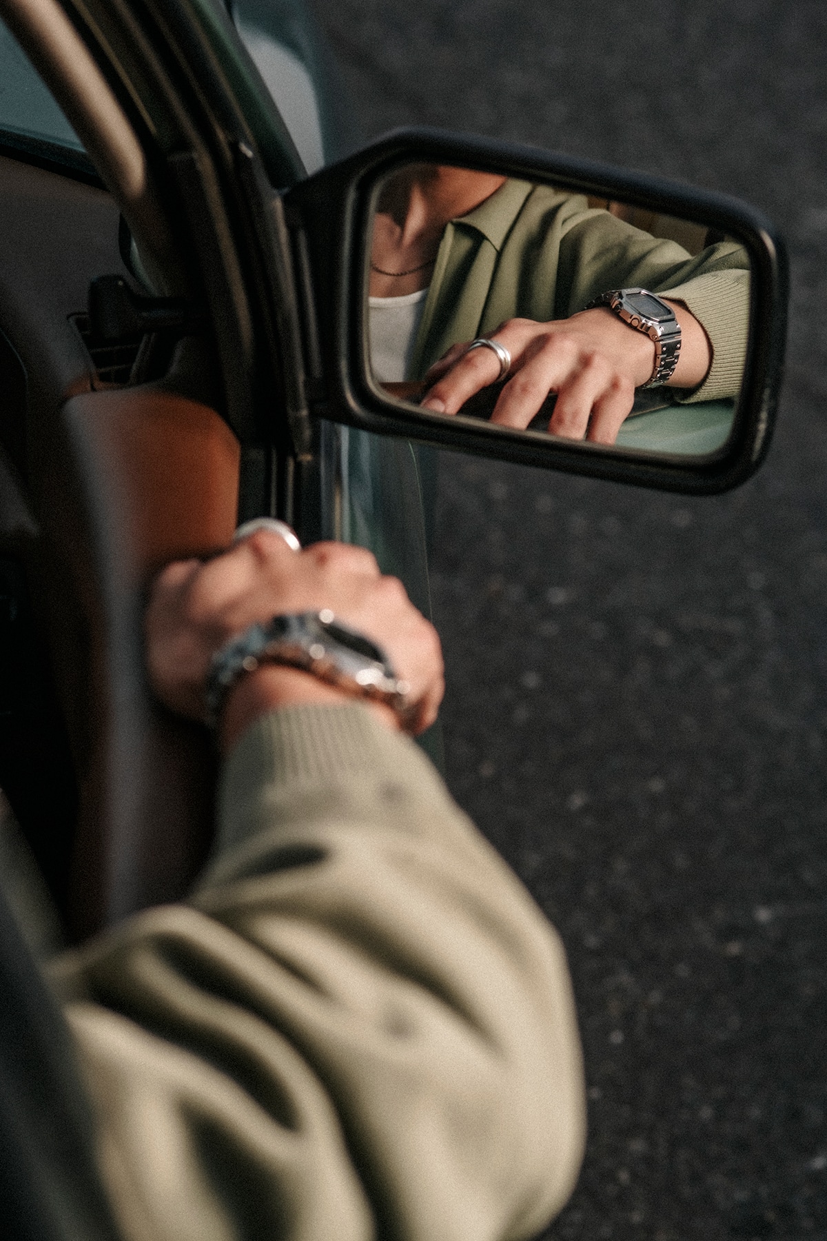 A man wearing a G-SHOCK watch sitting in a car.