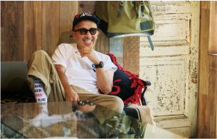 Il direttore artistico Ramdane Touhami, seduto su un divano, ride indossando un orologio G-Shock scuro al polso. L’immagine rimanda all’intervista THISTIME con Ramdane Touhami.