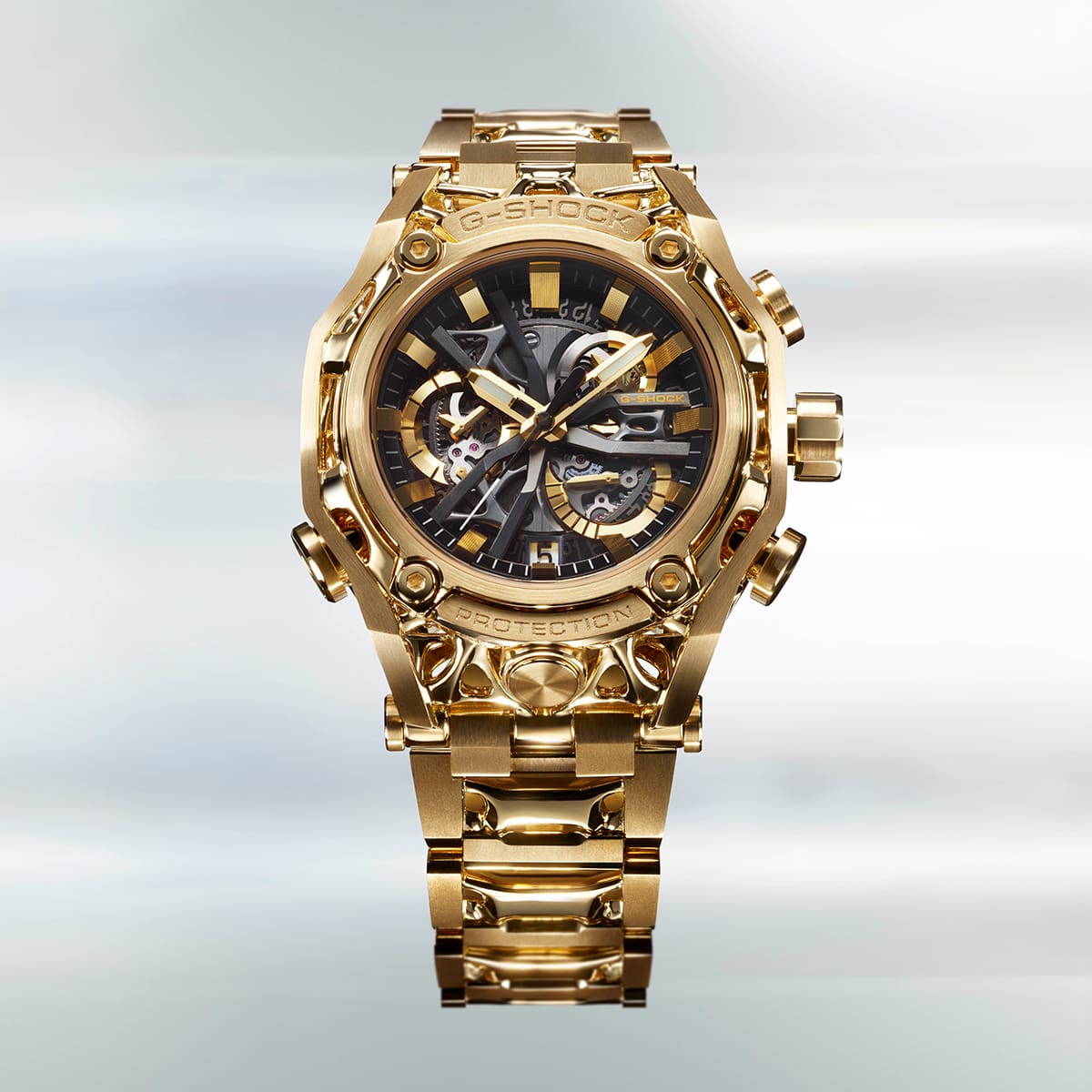 Orologio da polso G-D001 di G-SHOCK in oro con bracciale a maglie larghe, quadrante nero rotondo e tre grandi pulsanti a destra e uno a sinistra della cassa.