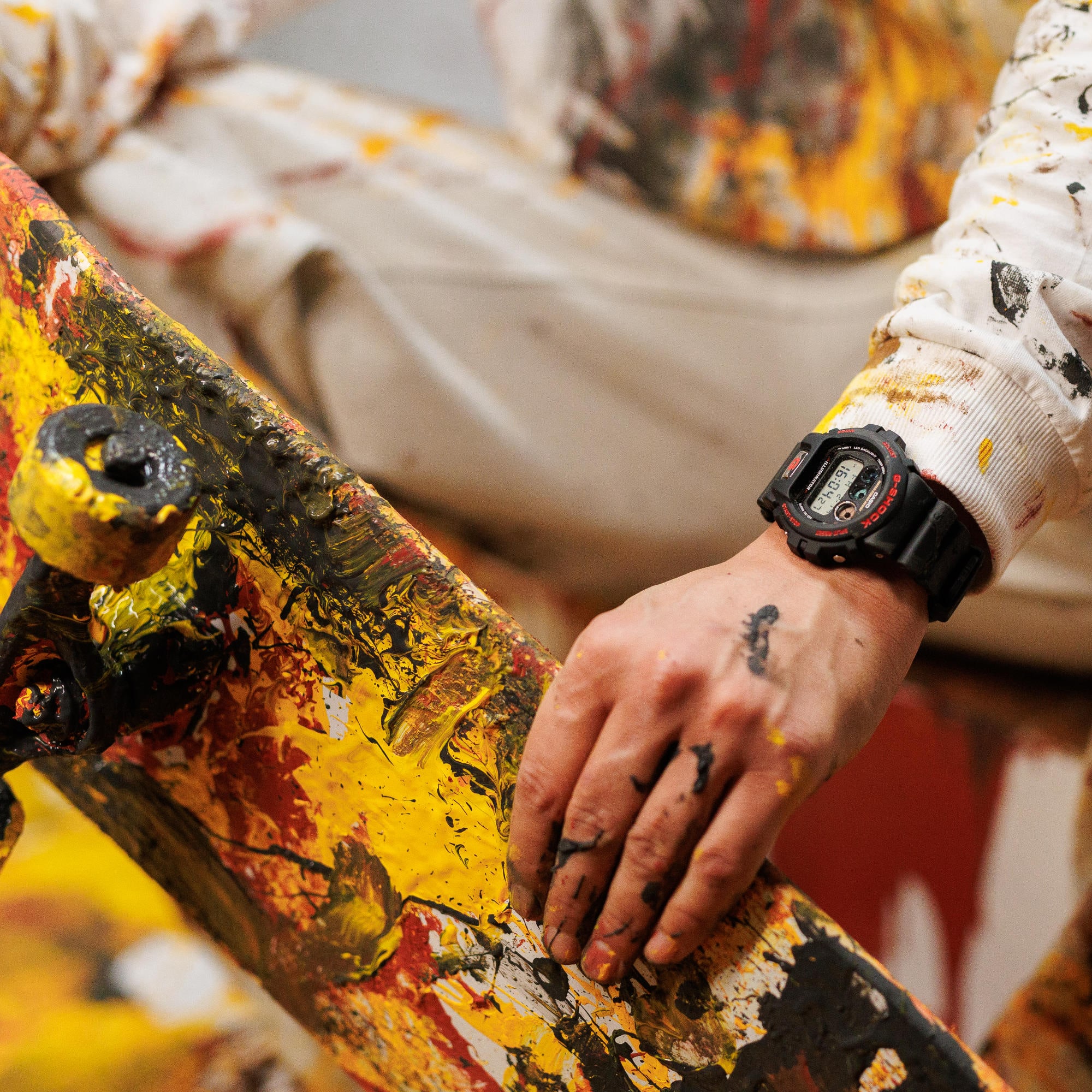 Un uomo tiene il suo skateboard indossando l'orologio digitale nero DW-6900TR-1ER di G-SHOCK