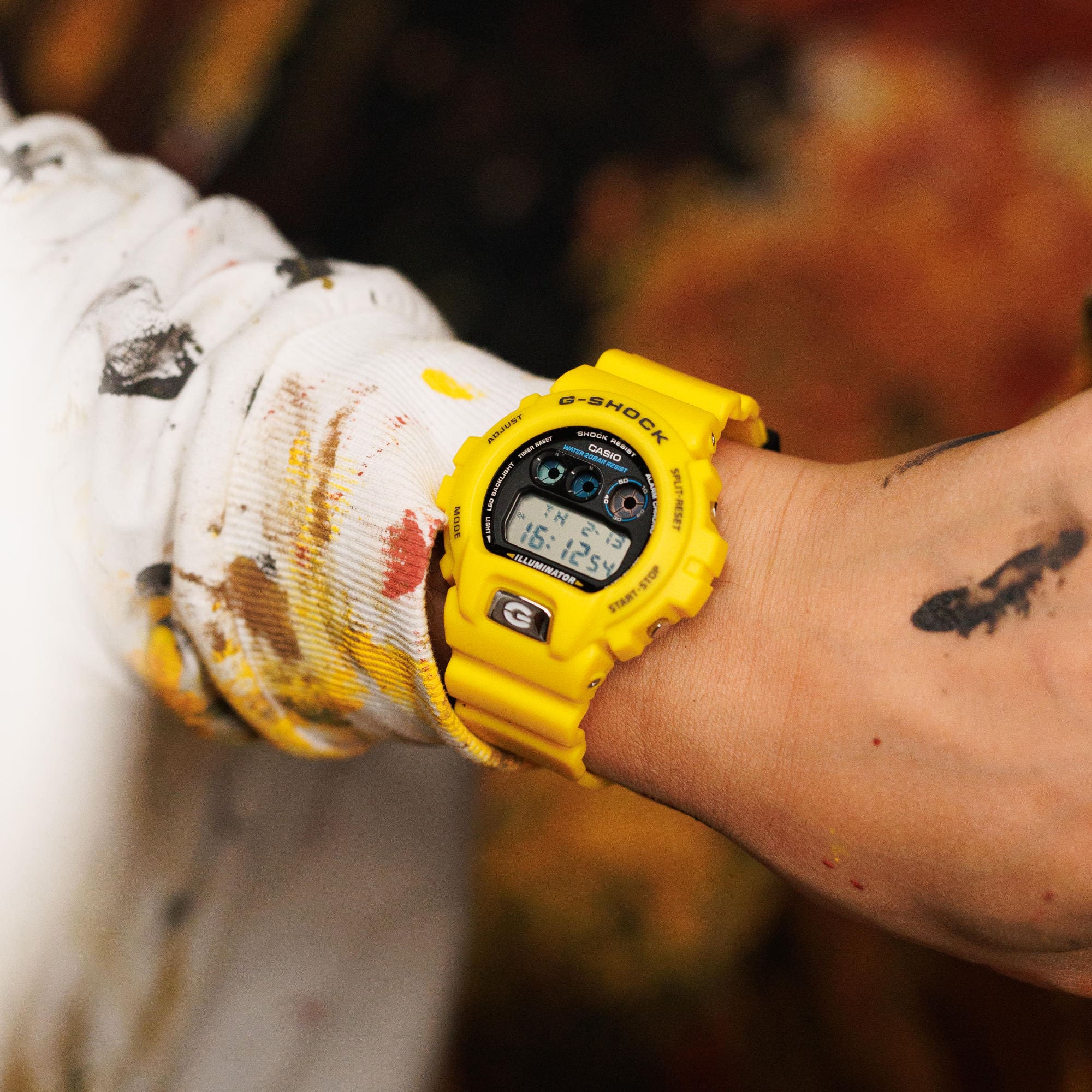 Primo piano del polso di un uomo che indossa l'orologio digitale giallo DW-6900TR