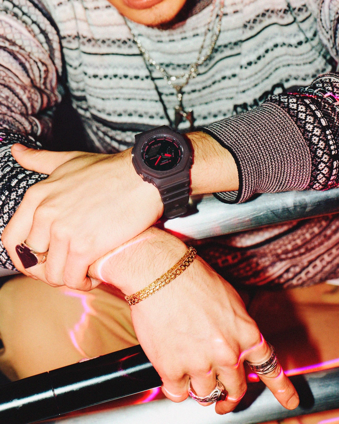 Primo piano su delle mani che indossano il G-Shock GA-2100K-5A in una scena di vita notturna.