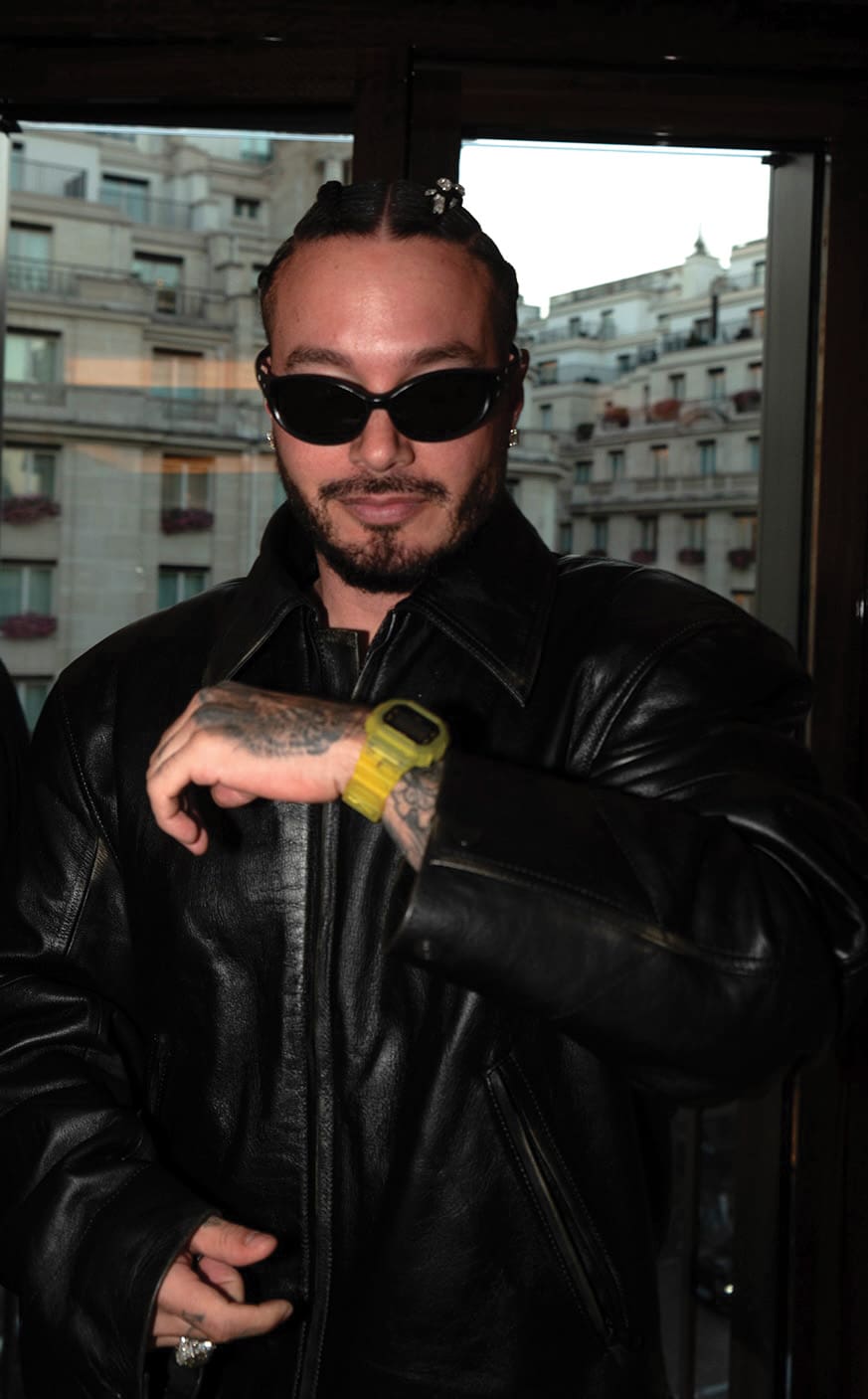 Il rapper J-Balvin indossa occhiali da sole, una giacca di pelle nera e l'orologio giallo brillante della collaborazione G-SHOCK