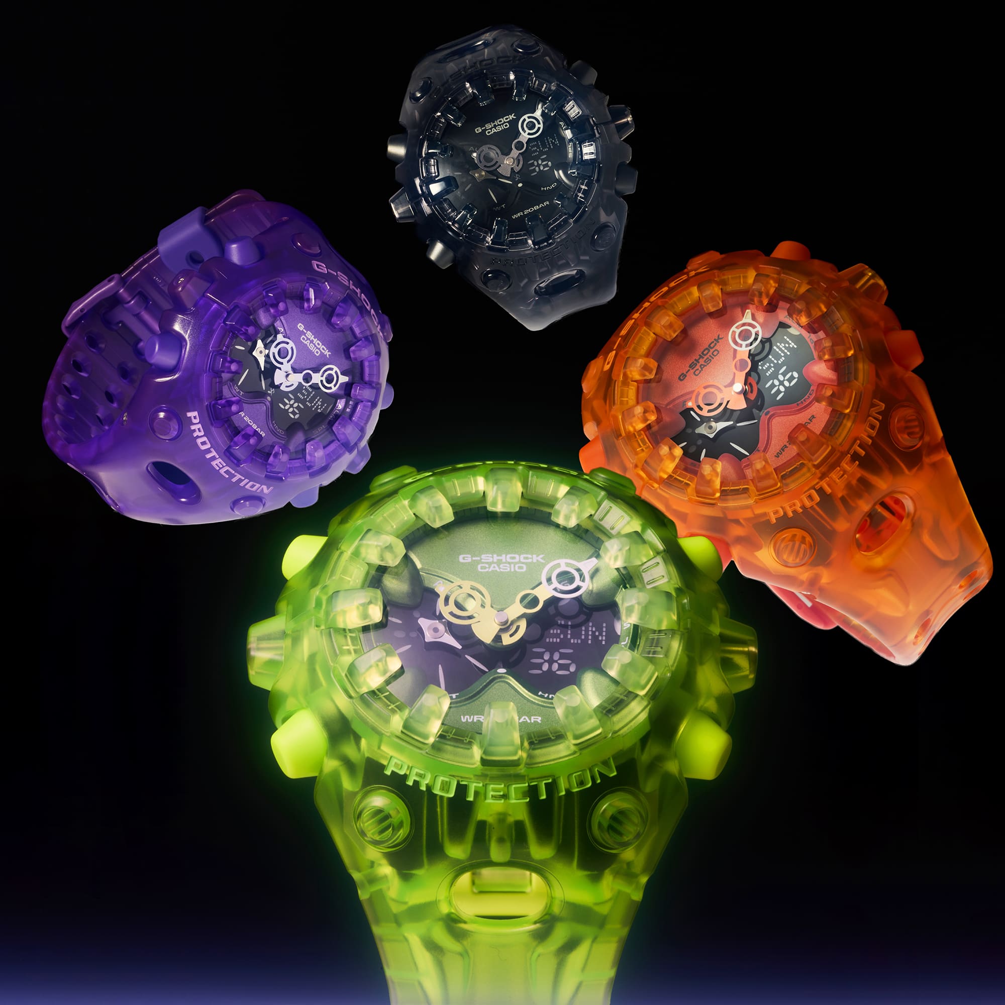 Vier G-SHOCK GA-V01-horloges met een doorzichtige kast in de neonkleuren groen, oranje, paars en zwart, gerangschikt tegen een zwarte achtergrond.
