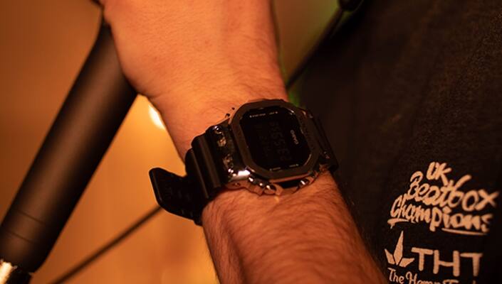 B-ART Beatbox draagt de zwarte G-SHOCK GM-5600-1 met zilverkleurige metalen kast en digitaal display om de pols.