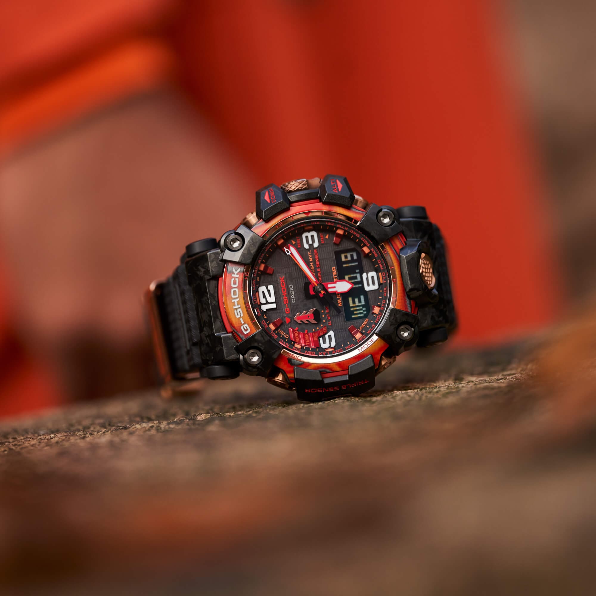 De GWG-2040FR-1AER chronograaf van de Special Edition met rode details op een betonnen achtergrond.