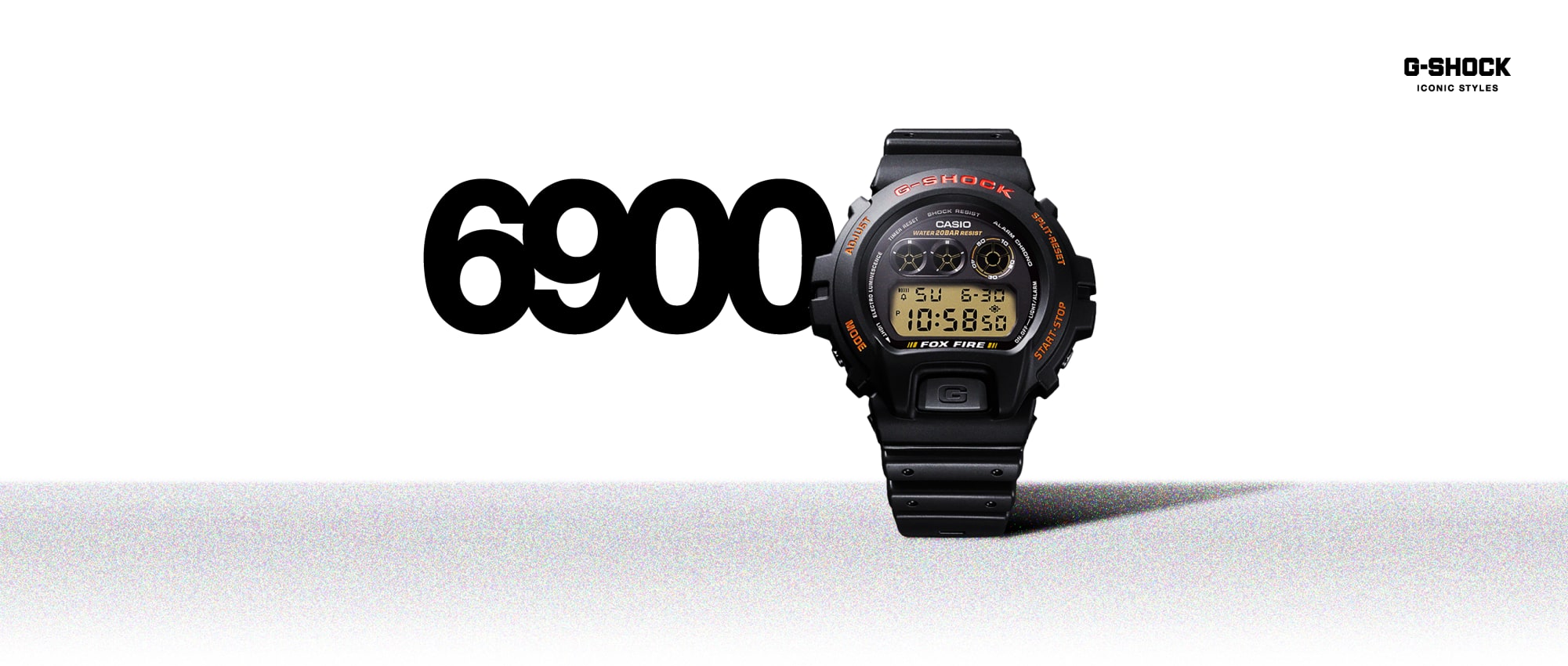O relógio digital redondo G-Shock 6900 com uma caixa grande, bracelete em resina preta e detalhes em vermelho