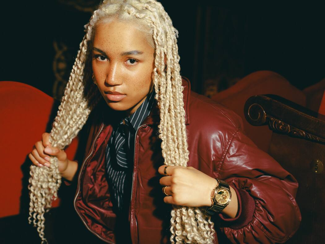 Uma jovem mulher com longas rastas loiras usa o GM-2100YMG-9A9ER