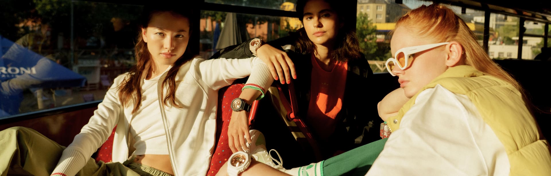 O relógio CASIO G-SHOCK GMA-S2100MD é usado por três jovens mulheres em cores diferentes. 