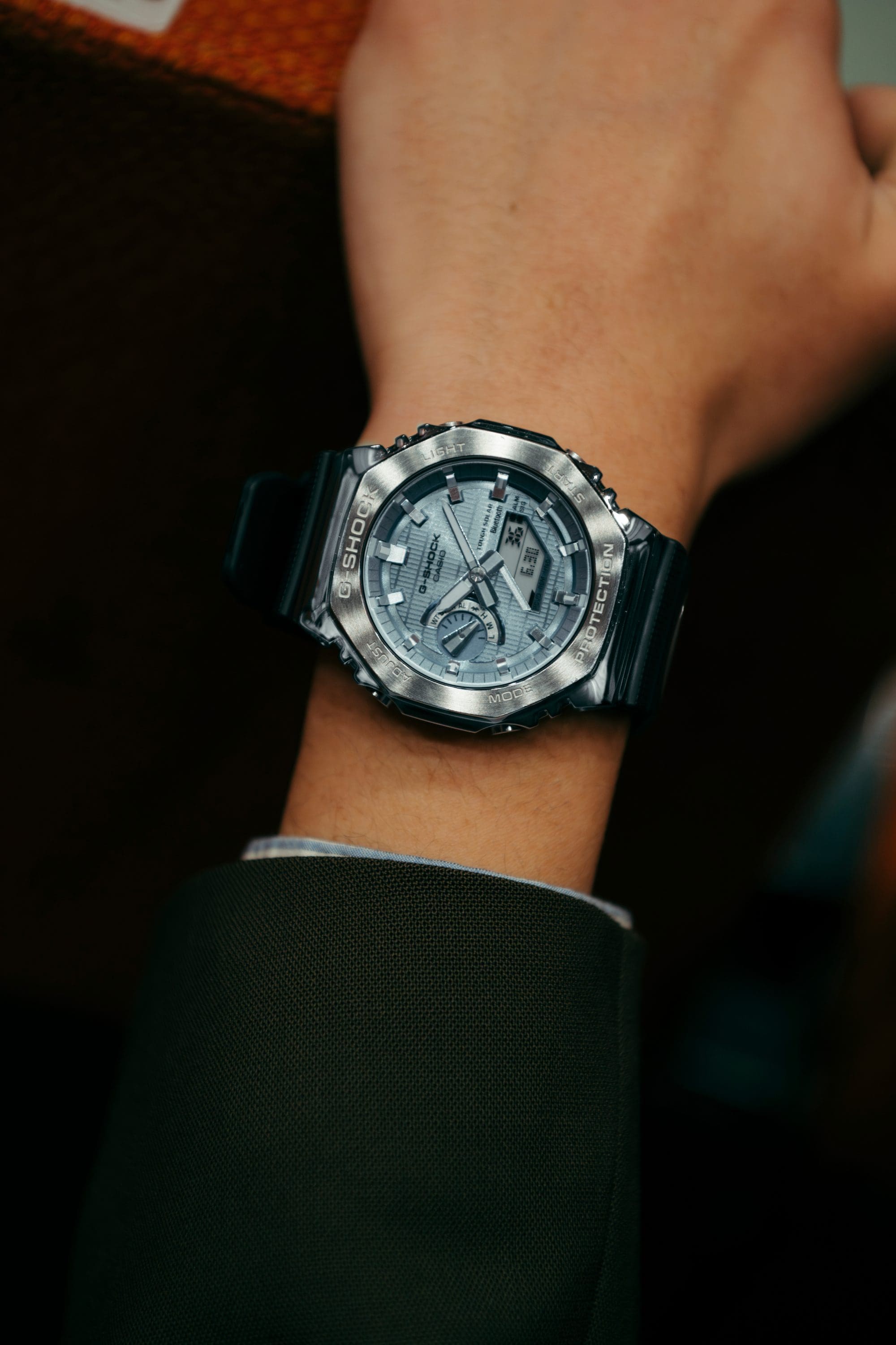 Close-up of G-SHOCK GBM-2100A with metal bezel in a lifestyle setting.