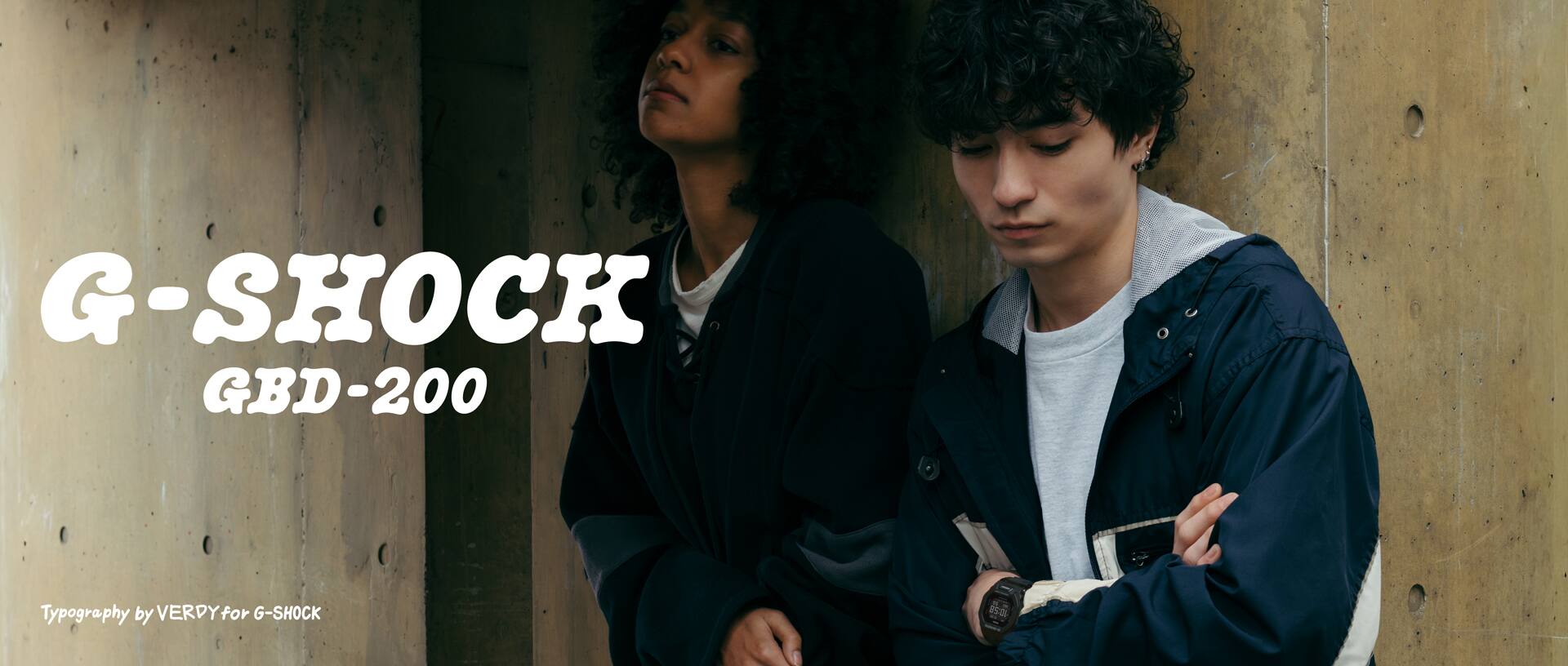 Two young people standing with a bicycle wearing G-SHOCK GBD-200 outdoors.