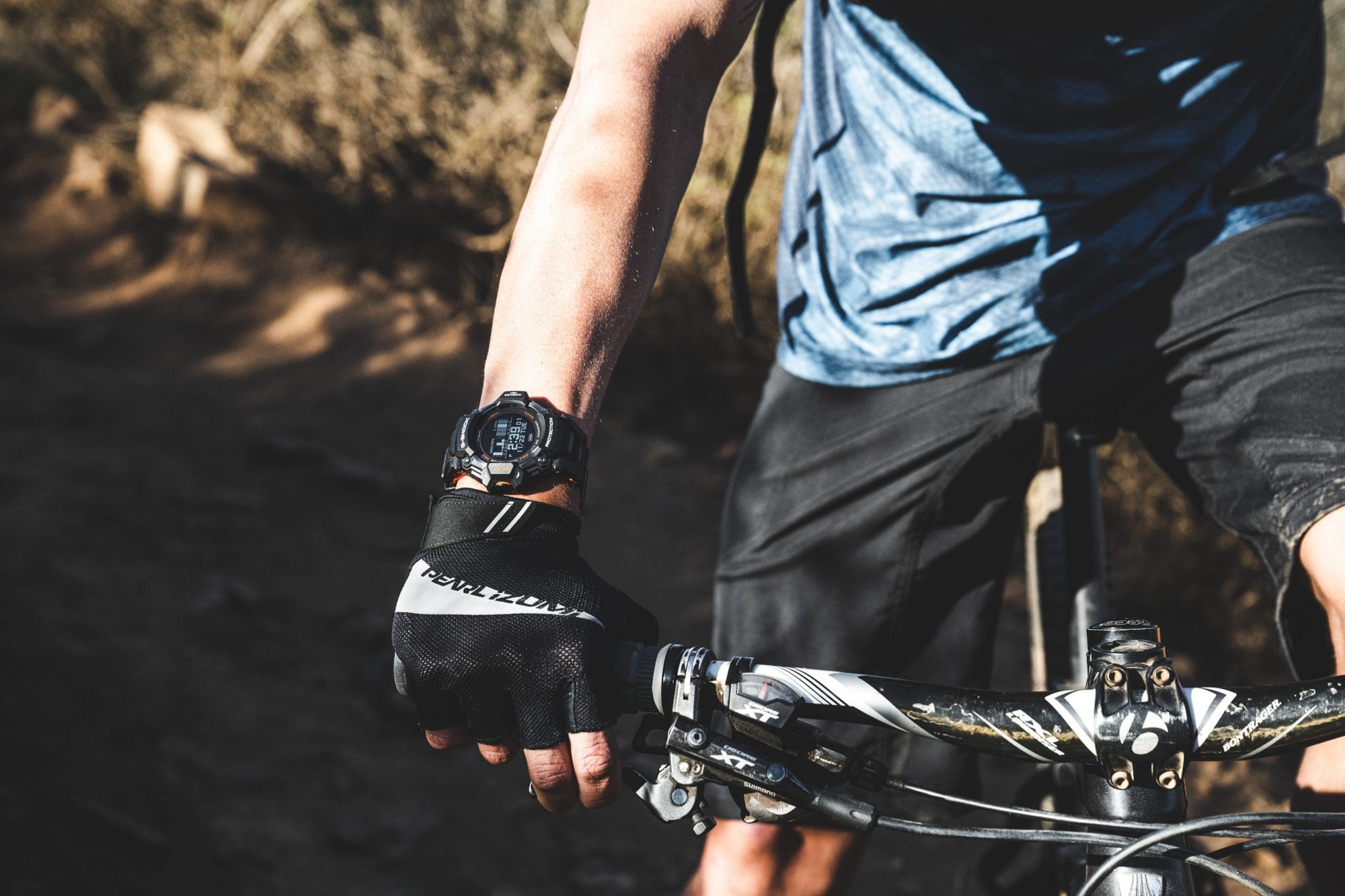 man wearing black G-SHOCK MOVE GBD-H2000-1A trail biking